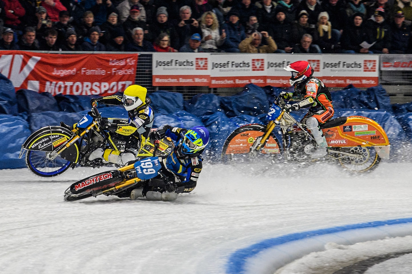 Sweden's Martin Haarahiltunen (199)  (Blue) leads  and Germany's Markus Jell (82) (Red) and Finland's Heikki Huusko (67)y\ collide and crash into the bales during the FIM Ice Speedway Gladiators World Championship Final 2 at the Max-Aicher-Arena, Inzell on Sunday 24 March 2024. (Photo: Ian Charles | MI News)