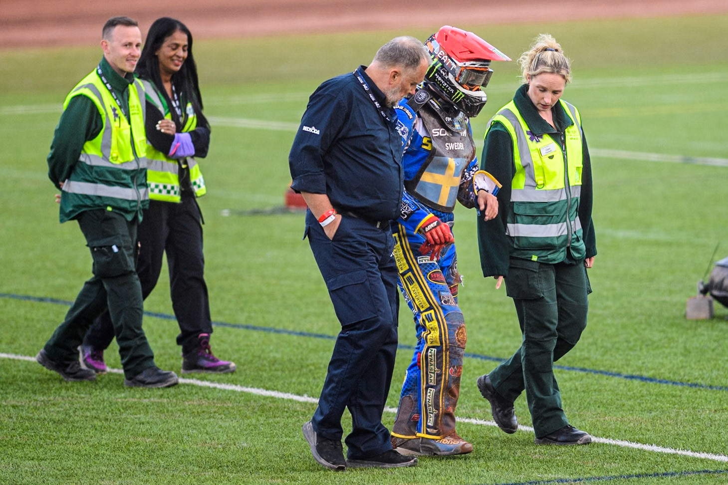 Fredrik Lindgren of Sweden walks back to the pits with the medical staff during the Monster Energy FIM Speedway of Nation Final at the National Speedway Stadium, Manchester on Saturday 13th July 2024. (Photo: Ian Charles | MI News)
