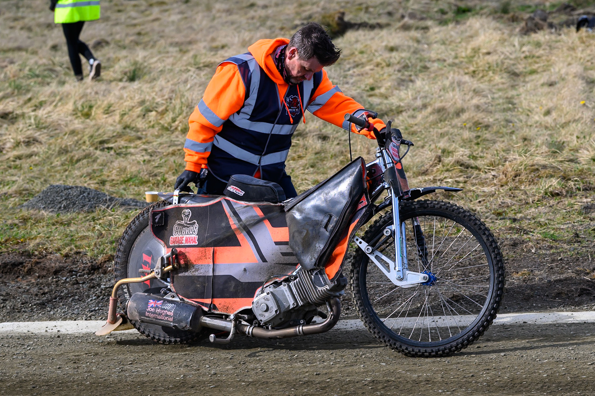 A track Marshall pushes Connor Coles' bike back to the pits after his fall during the  Challenge match between Buxton Bulls and NDL Nomads at Hi-Edge Speedway, Buxton on Sunday 19th April 2026. (Photo: Ian Charles | MI News)