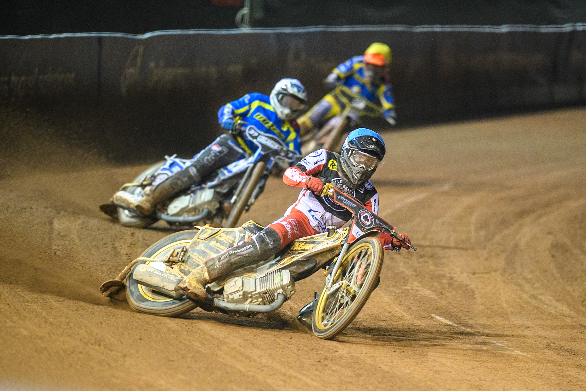 Belle Vue Aces' Norick Blodorn  in Blue leading Sheffield Tigers' Guest Rider Chris Harris  in White and Sheffield Tigers' Jason Edwards  in Yellow during the Rowe Motor Oil Premiership Play Off Semi Final 2, 1st Leg match between Belle Vue Aces and Sheffield Tigers at the National Speedway Stadium, Manchester on Monday 16th September 2024. (Photo: Ian Charles | MI News)