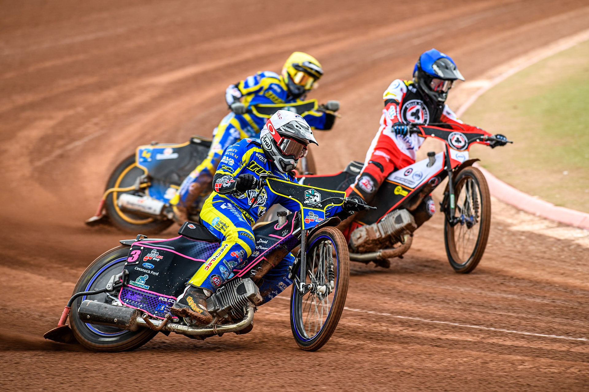 Josh Pickering of Sheffield Tigers in White rides outside Zach Cook of Belle Vue Aces in Blue and Justin Sedgmen of Sheffield Tigers in Yellow during the Rowe Motor Oil Premiership match between Belle Vue Aces and Sheffield Tigers at the National Speedway Stadium, Manchester on Monday 5th May 2025. (Photo: Ian Charles | MI News)