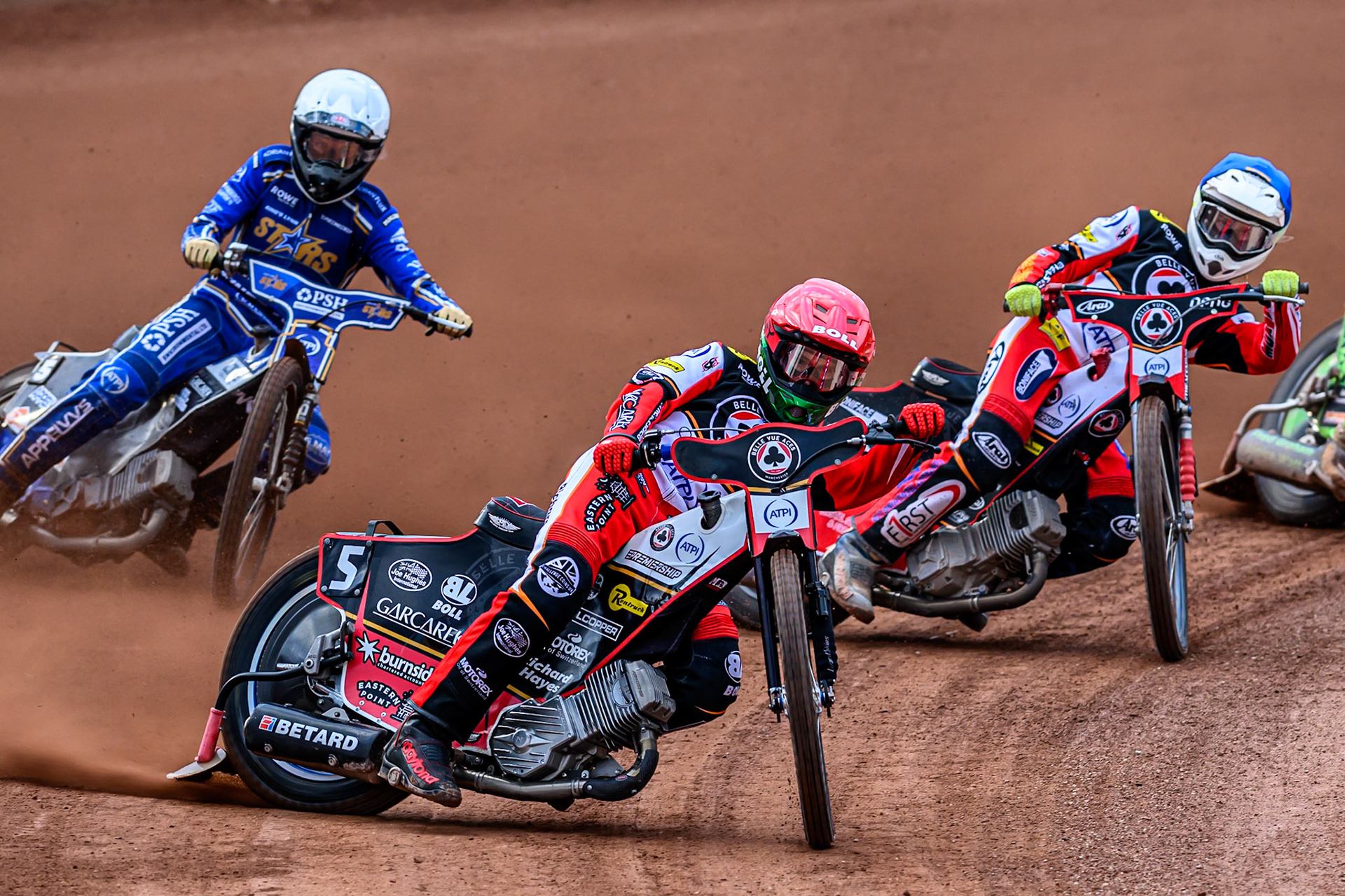 Belle Vue Aces' Brady Kurtz in Red leading Kings Lynn Stars' Nicolai Klindt in White and Belle Vue Aces' Jake Mulford in Blue during the Rowe Motor Oil Premiership match between Belle Vue Aces and King's Lynn Stars at the National Speedway Stadium, Manchester on Monday 23rd June 2025. (Photo: Ian Charles | MI News)