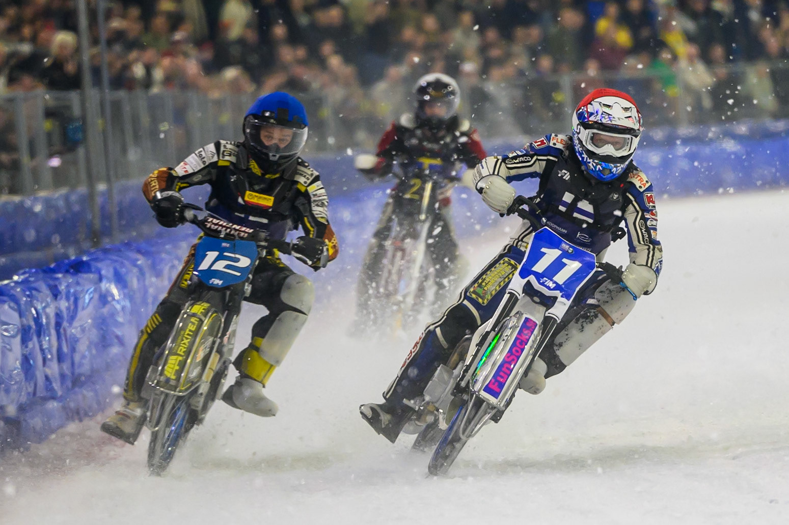 Max Koivula (11) of Finland  in Red and Heikki Huusko (12) of Finland  in Blue team ride to keep Ove Ledstrom (2) of Sweden  in White in last place during the FIM Ice Speedway Of Nations at Ice Rink Thialf, Heerenveen on Sunday 12th April 2026. (Photo: Ian Charles | MI News)