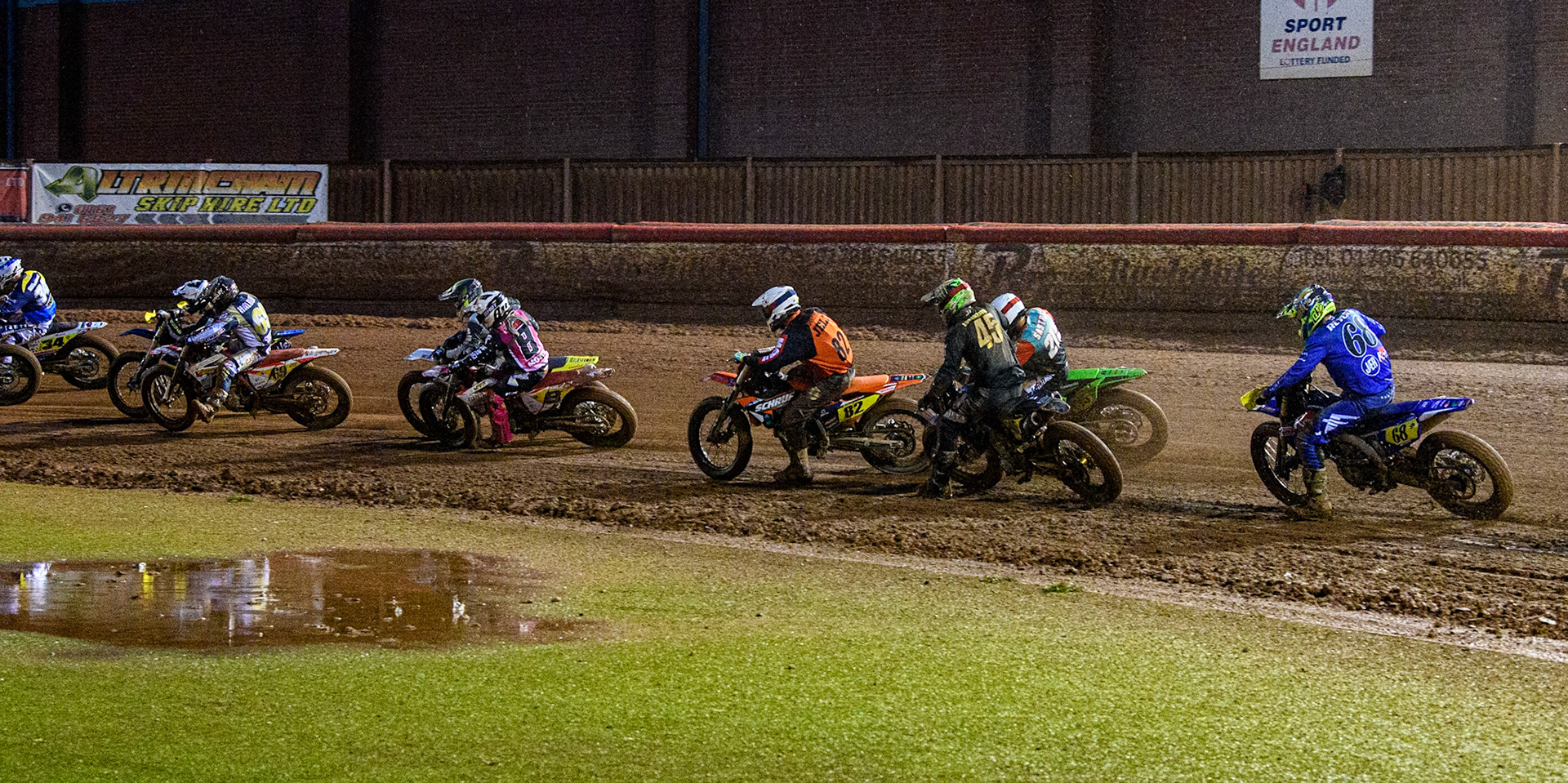 The pack in the first turn during the FIM World Flat Track Championship Round 1 at the National Speedway Stadium, Manchester on Saturday 5th August 2023. (Photo: Ian Charles | MI News)