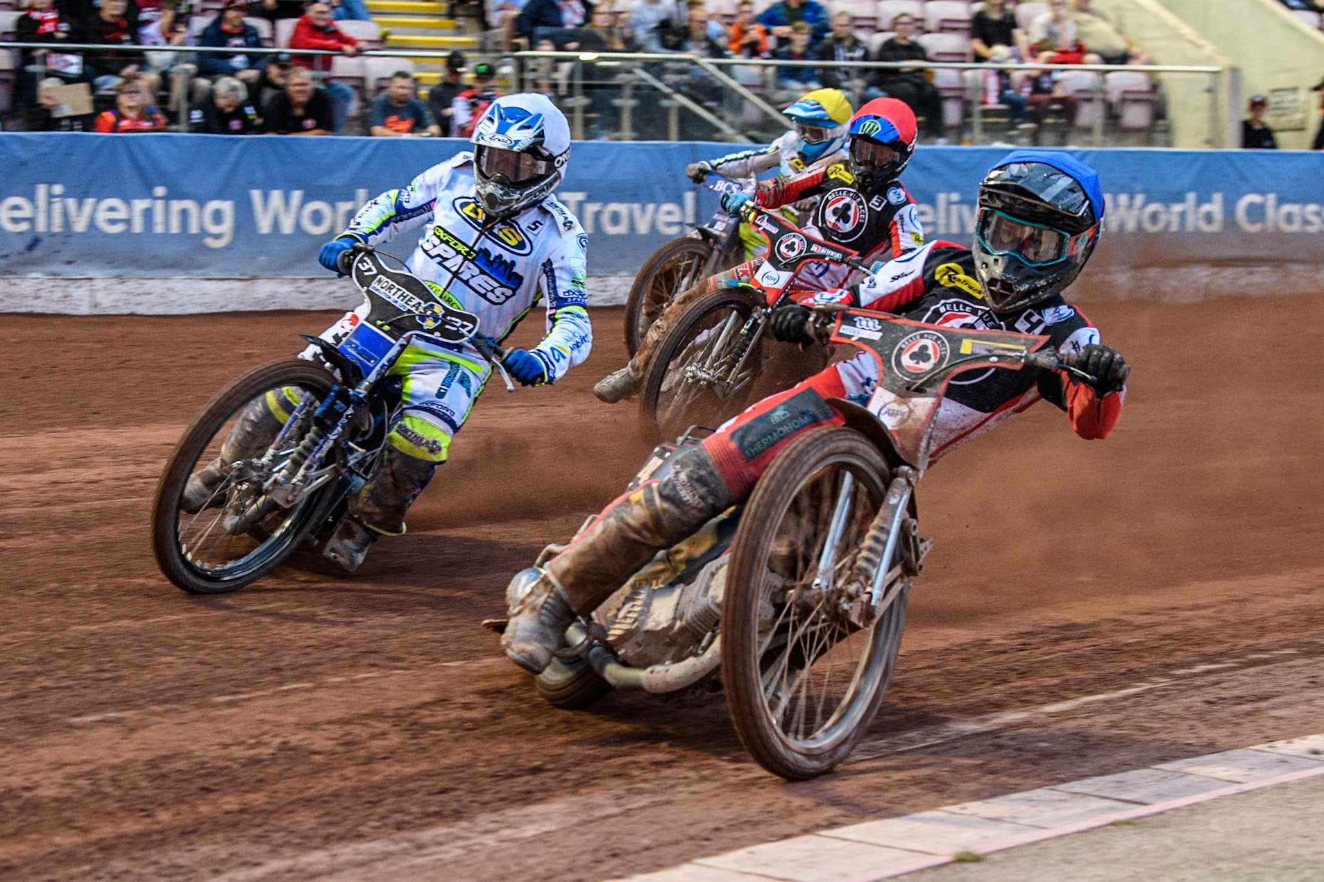 Belle Vue Aces' Ben Cook  in Blue rides inside Oxford Spires' Chris Harris  in White with Belle Vue Aces' Jaimon Lidsey in Red and Oxford Spires' Ashton Boughen in Yellow behind during the Rowe Motor Oil Premiership match between Belle Vue Aces and Oxford Spires at the National Speedway Stadium, Manchester on Monday 22nd July 2024. (Photo: Ian Charles | MI News)