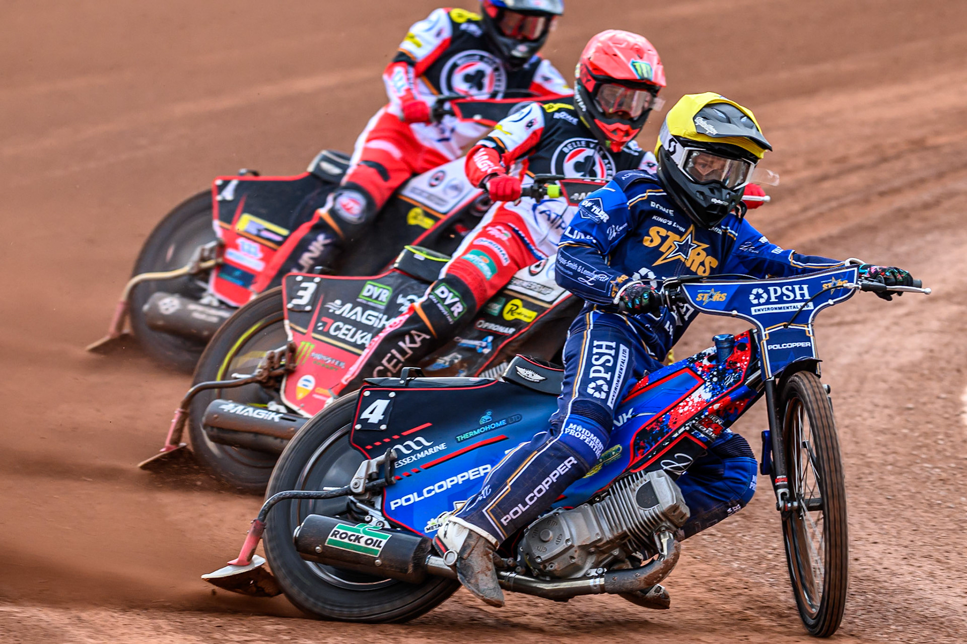 Kings Lynn Stars' Ben Cook in Yellow leading Belle Vue Aces' Jaimon Lidsey in Red and Belle Vue Aces' Zach Cook in Blue during the Rowe Motor Oil Premiership match between Belle Vue Aces and King's Lynn Stars at the National Speedway Stadium, Manchester on Monday 23rd June 2025. (Photo: Ian Charles | MI News)