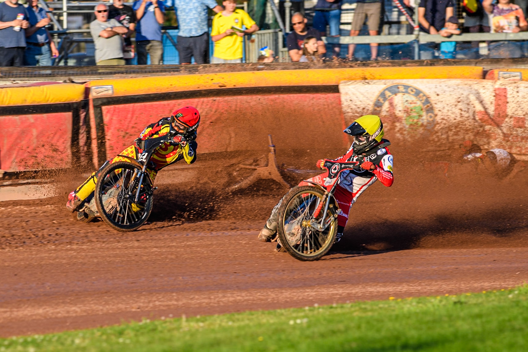 Belle Vue Aces' Brady Kurtz falls on the first turn of the opening lap behind Birmingham Brummies' Freddie Lindgren in Red and Belle Vue Aces' Norick Blodorn in Yellow during the Rowe Motor Oil Premiership match between Birmingham Brummies and Belle Vue Aces at Perry Bar Stadium, Birmingham on Monday 29th July 2024. (Photo: Ian Charles | MI News)