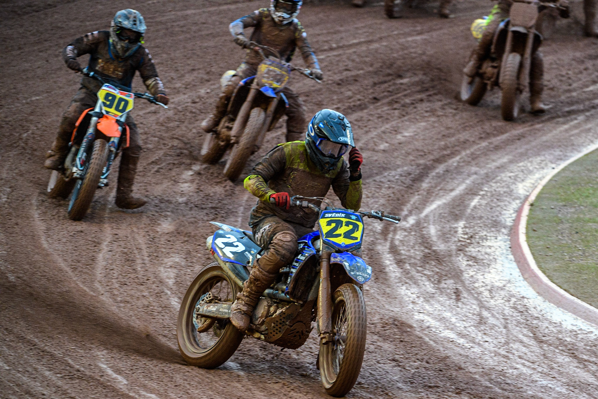 Ondřej Svědík (22) from Czech Rep. rips off his tear off as he ;ears Daniele Tonelli (90) from Italy and Tim Neave (54) from Great Britain during the FIM World Flat Track Championship Round 1 at the National Speedway Stadium, Manchester on Saturday 5th August 2023. (Photo: Ian Charles | MI News)