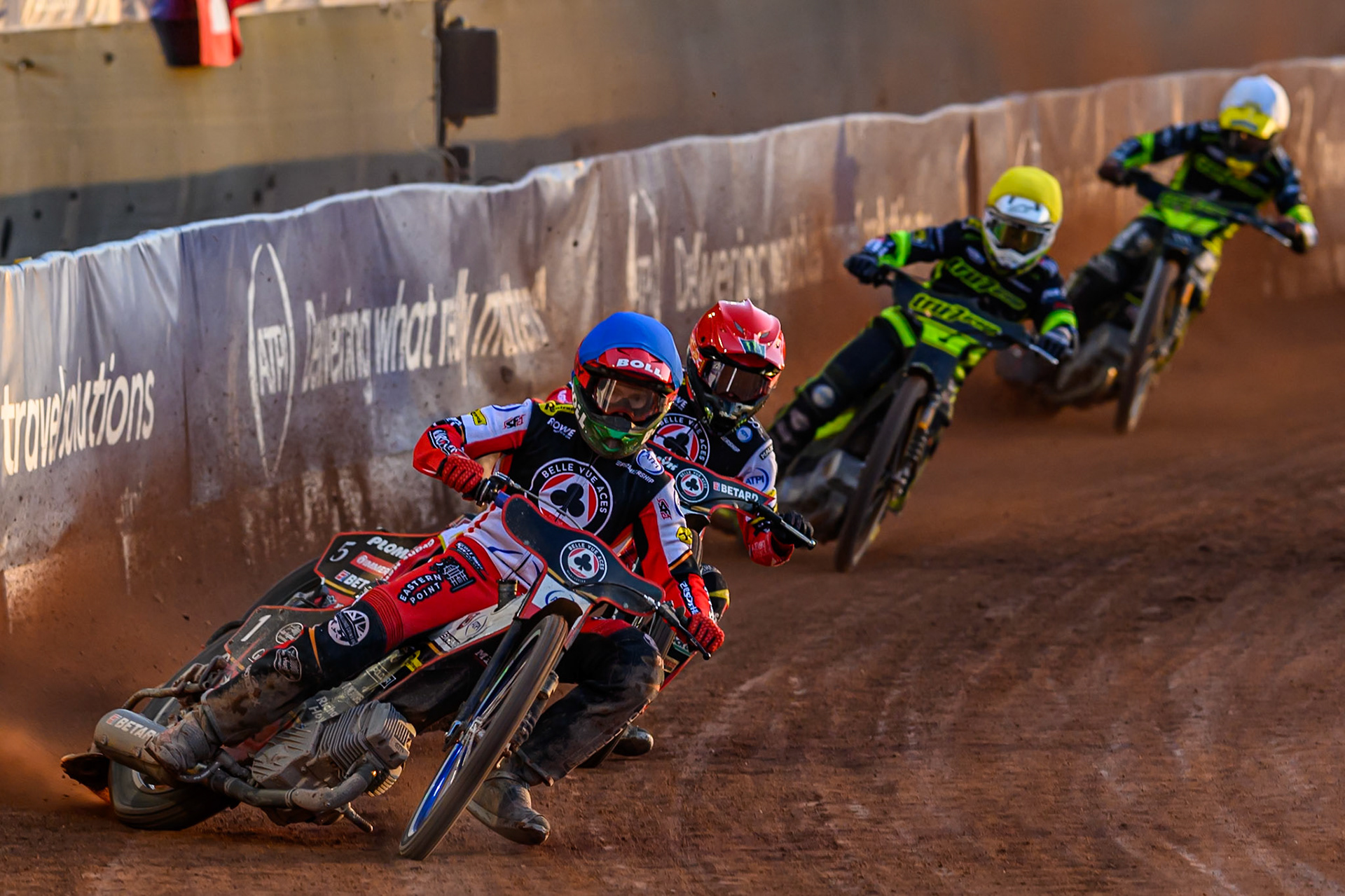 Brady Kurtz of Belle Vue Aces  in Blue and Dan Bewley of Belle Vue Aces  in Red leading Tom Brennan of Ipswich Witches  in Yellow and Adam Ellis of Ipswich Witches  in White during the Rowe Motor Oil Premiership match between Belle Vue Aces and Ipswich Witches at the National Speedway Stadium, Manchester on Monday 4th August 2025. (Photo: Ian Charles | MI News)