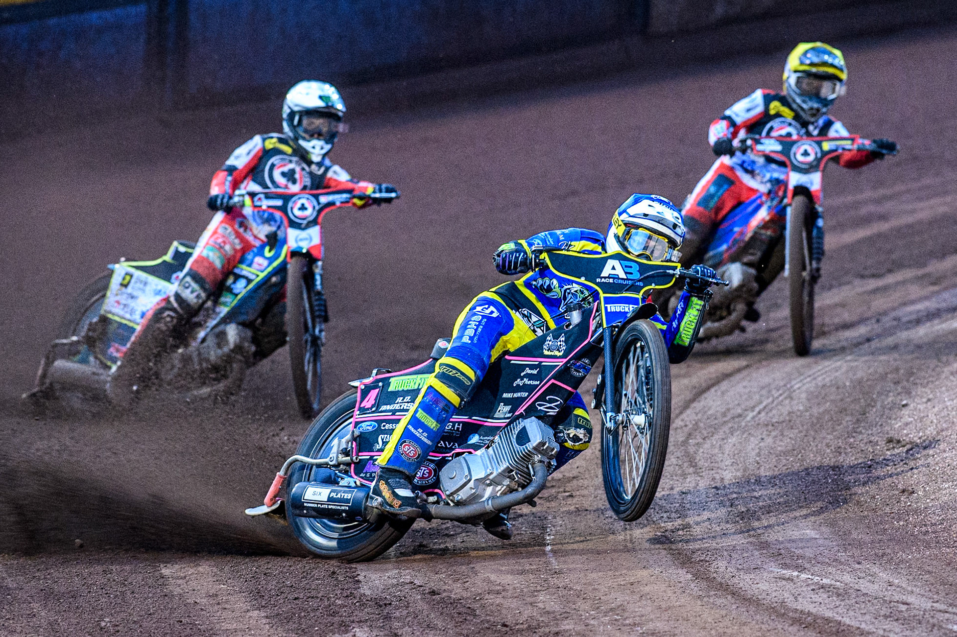 Sheffield Tigers' Josh Pickering  in Blue picks up some drive whilst leading Belle Vue Aces' Jaimon Lidsey  in White and Belle Vue Aces' Ben Cook  in Yellow during the Rowe Motor Oil Premiership match between Sheffield Tigers and Belle Vue Aces at Owlerton Stadium, Sheffield on Monday 26th August 2024. (Photo: Ian Charles | MI News)
