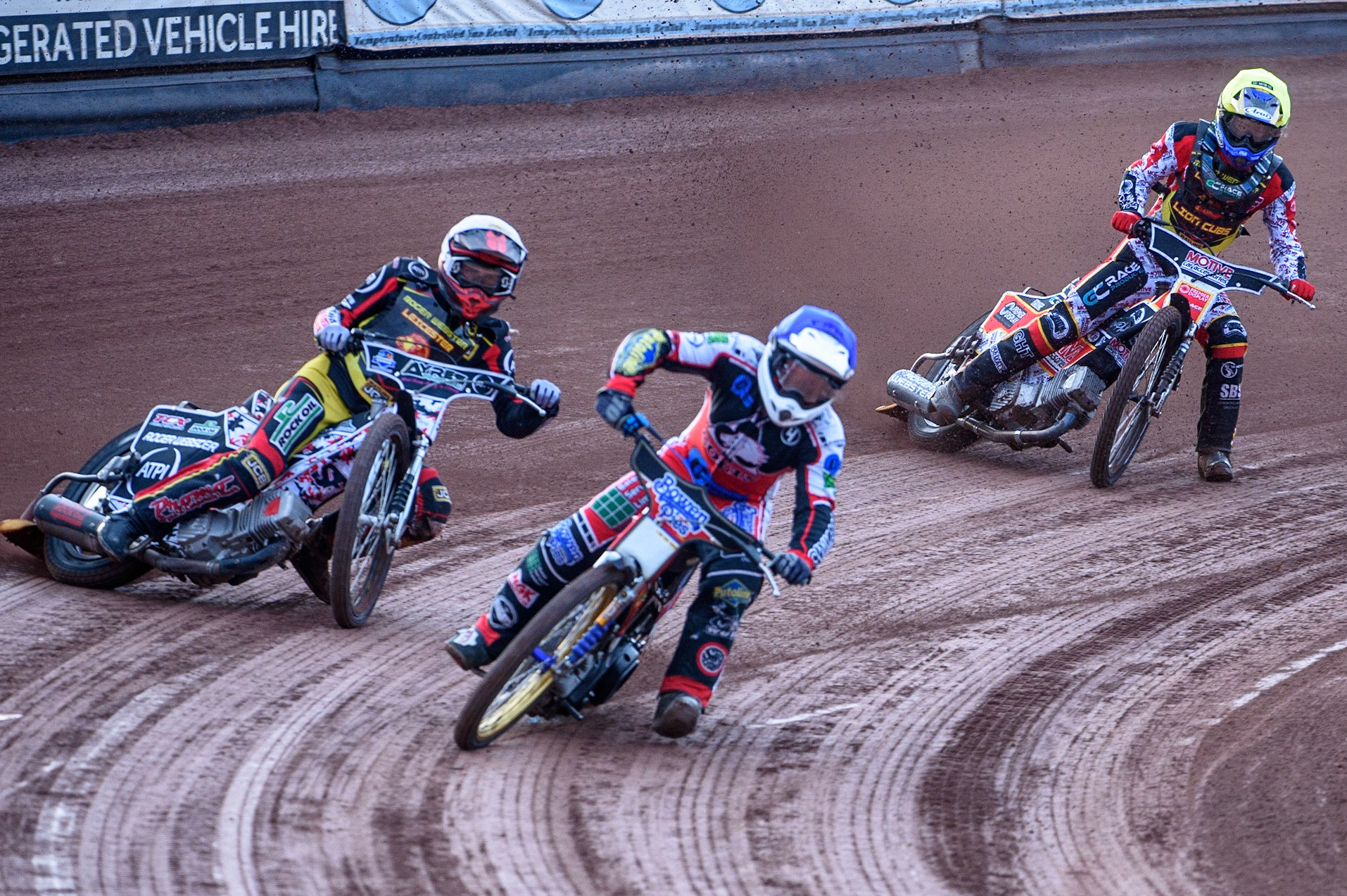 MANCHESTER, UK. JULY 29TH  Paul Bowen  (Blue) picks up some drive causing him to fall as he leads Joe Lawlor  (White) and Tom Spencer   (Yellow)  during the National Development League match between Belle Vue Colts and Leicester Lion Cubs at the National Speedway Stadium, Manchester on Thursday 29th July 2021. (Credit: Ian Charles | MI News)