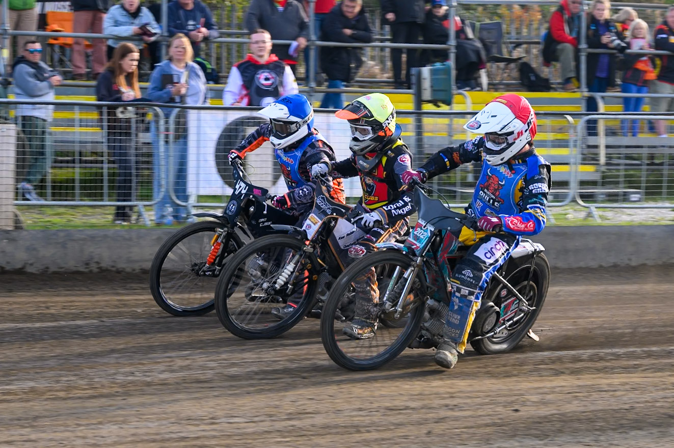 Alfie Bowtell of Buxton Bulls  in Red on the inside of Ryan Ingram of Leicester Lion Cubs   in Yellow  and Jack Roberts of Buxton Bulls   in Blue during the WSRA National Development League match between Buxton Bulls and Leicester Lion Cubs at Hi-Edge Speedway, Buxton on Sunday 4th October 2026. (Photo: Ian Charles | MI News)