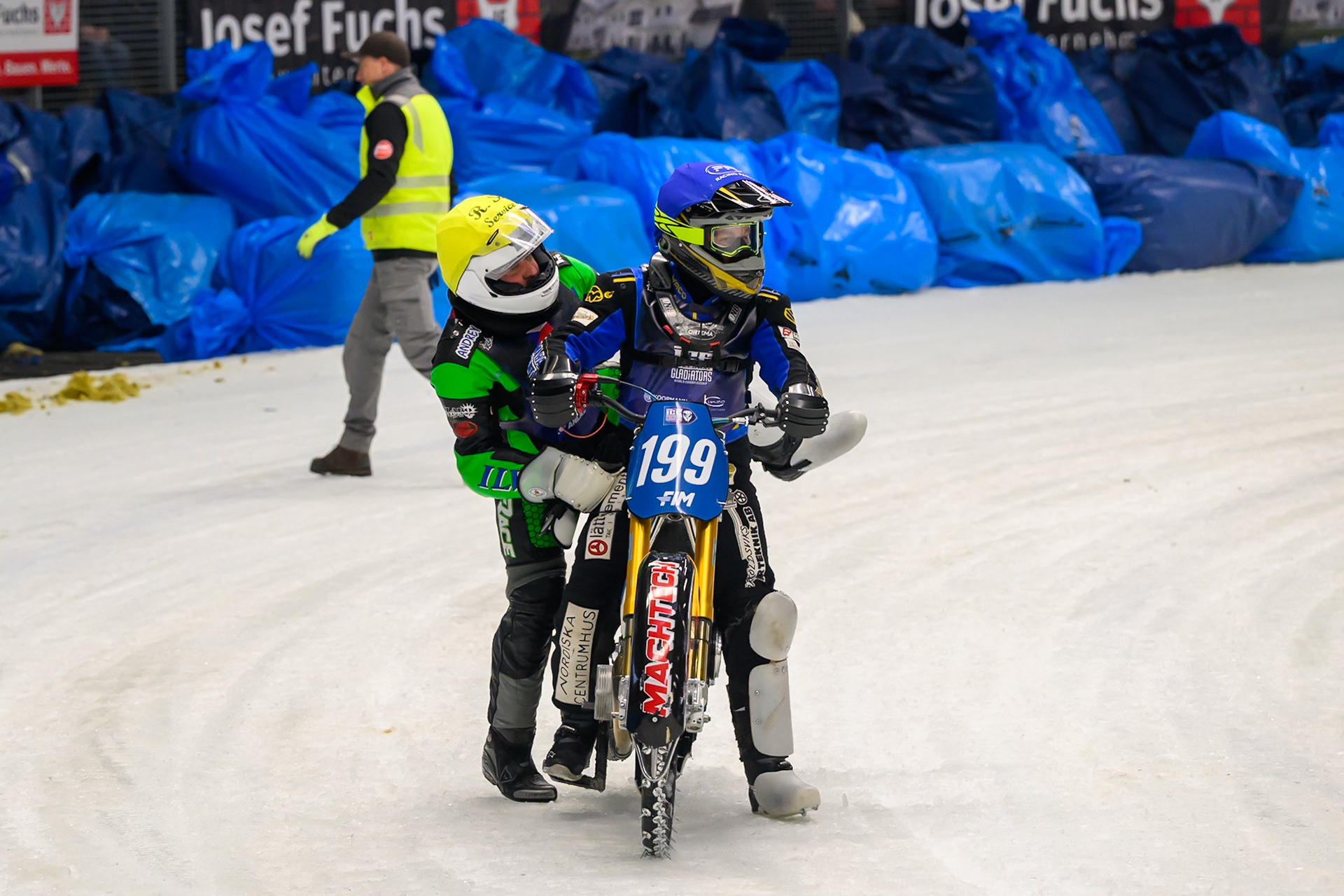 Andrej Divis (107) of Czechia gets a ride back to the pits after his fall from Martin Haarahiltunen (199) of Sweden during the Ice Speedway Gladiators World Championship Final 2 at Max-Aicher-Arena, Inzell on Sunday 15th March 2026. (Photo: Ian Charles | MI News)