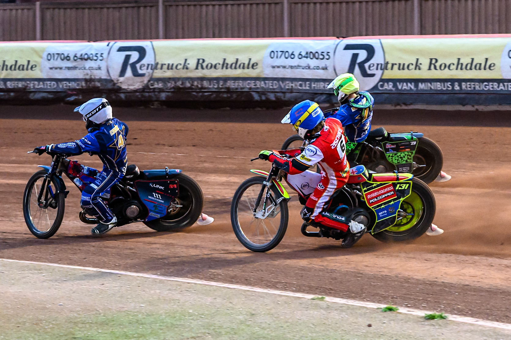 Belle Vue Aces' Tate Zischke in Blue chases Kings Lynn Stars' Guest Rider, Anders Rowe in Yellow and Kings Lynn Stars' Ben Cook in White during the Rowe Motor Oil Premiership match between Belle Vue Aces and King's Lynn Stars at the National Speedway Stadium, Manchester on Monday 23rd June 2025. (Photo: Ian Charles | MI News)