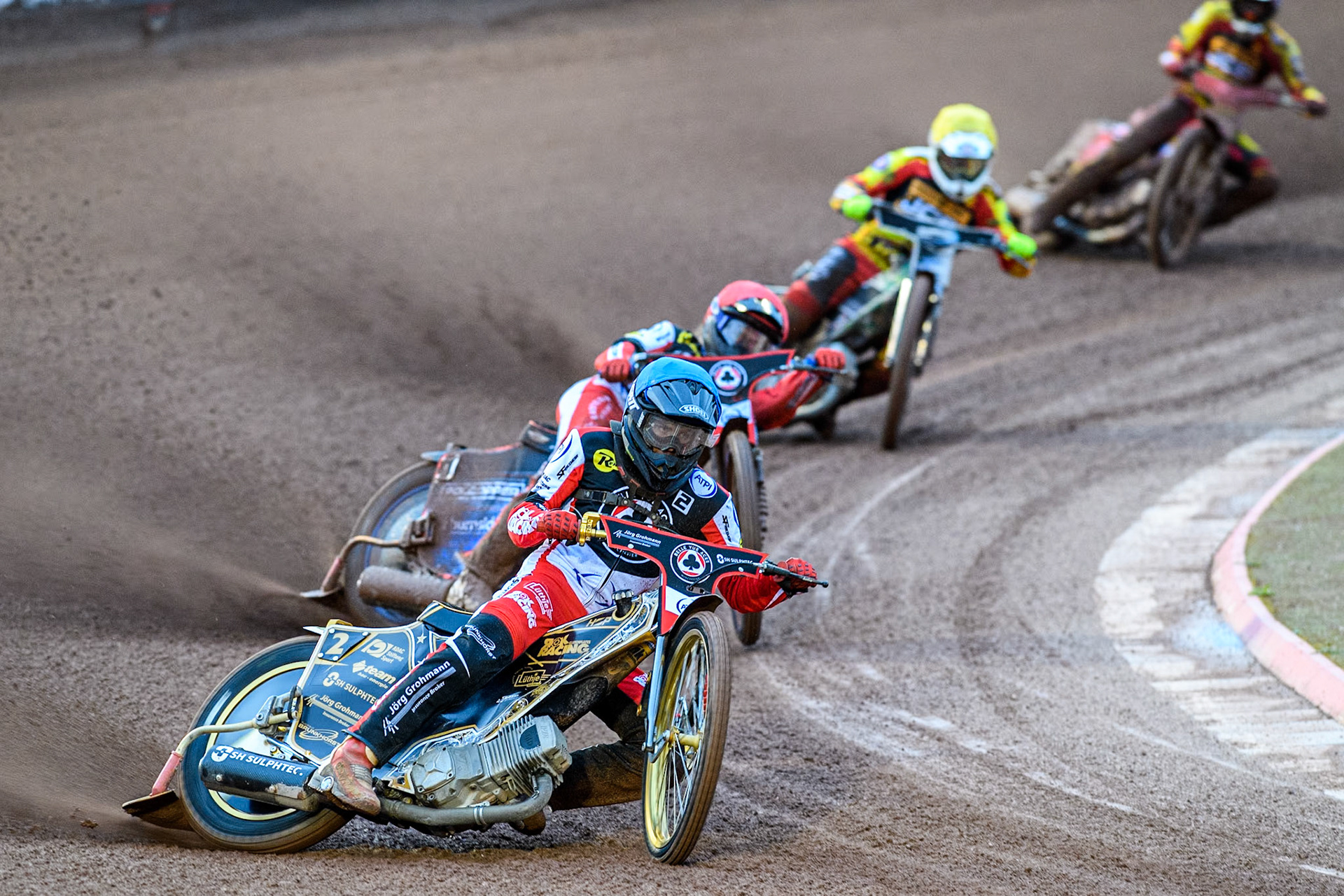 Norick Blödorn of Belle Vue Aces in Blue leading team mate Brady Kurtz of Belle Vue Aces in Red with Richard Lawson of Leicester Lions in Yellow and Max Fricke of Leicester Lions in White behind during the Rowe Motor Oil Premiership match between Belle Vue Aces and Leicester Lions at the National Speedway Stadium, Manchester on Saturday 6th April 2024. (Photo: Ian Charles | MI News)