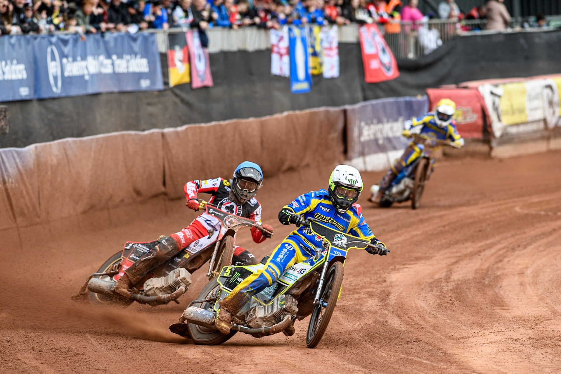 Chris Holder of Sheffield Tigers in White leading Norick Blödorn of Belle Vue Aces in Blue’ and Lewis Kerr of Sheffield Tigers in Yellow during the Rowe Motor Oil Premiership match between Belle Vue Aces and Sheffield Tigers at the National Speedway Stadium, Manchester on Monday 5th May 2025. (Photo: Ian Charles | MI News)