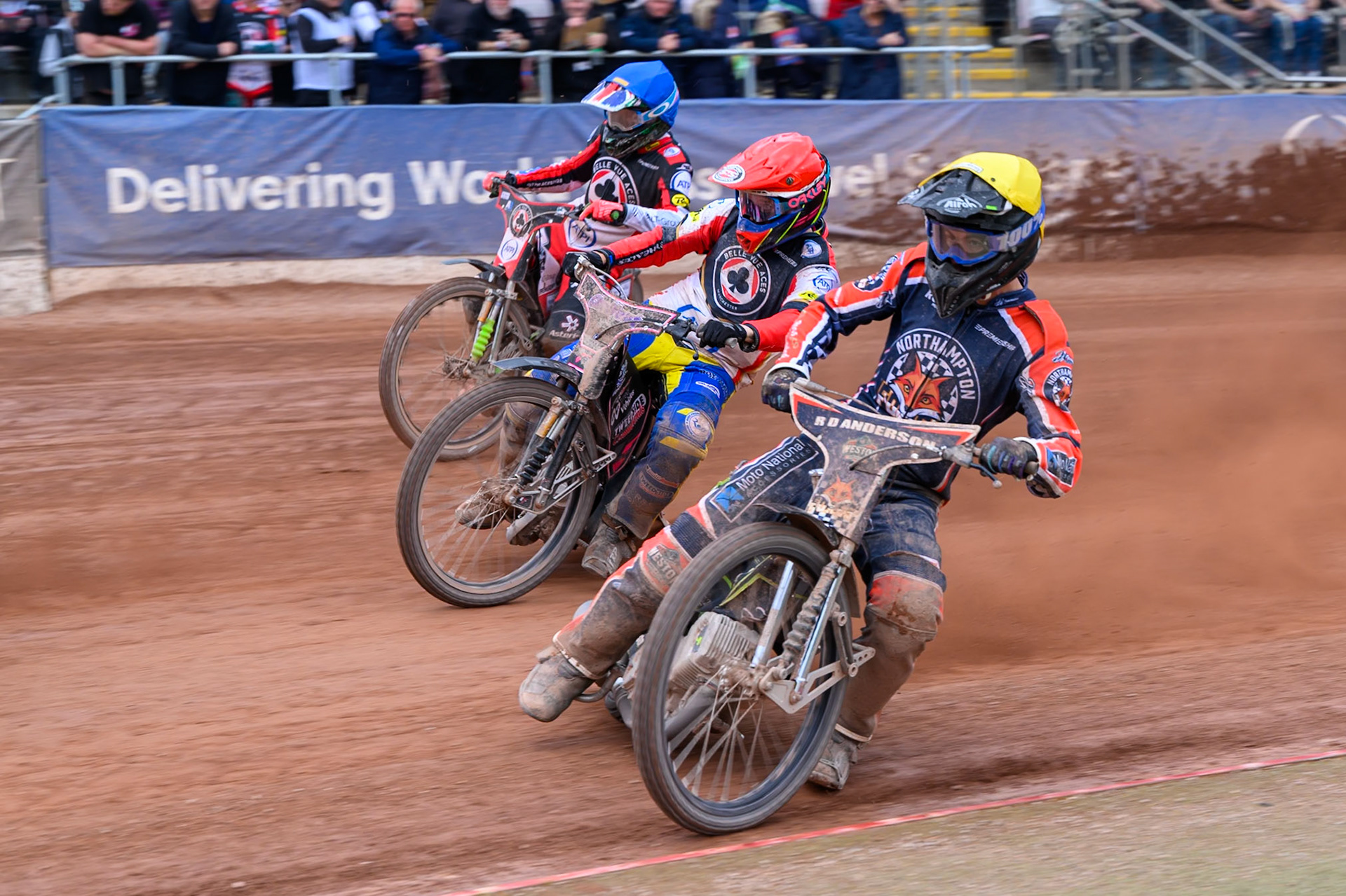 Kye Thomson of Northampton Foxes in Yellow rides inside Leon Flint, Guest Rider for Belle Vue Aces in Red and Will Cairns of Belle Vue Aces in Blue during the Rowe Motor Oil Premiership match between Belle Vue Aces and Northampton Foxes at the National Speedway Stadium, Manchester on Monday 4th May 2026. (Photo: Ian Charles | MI News)