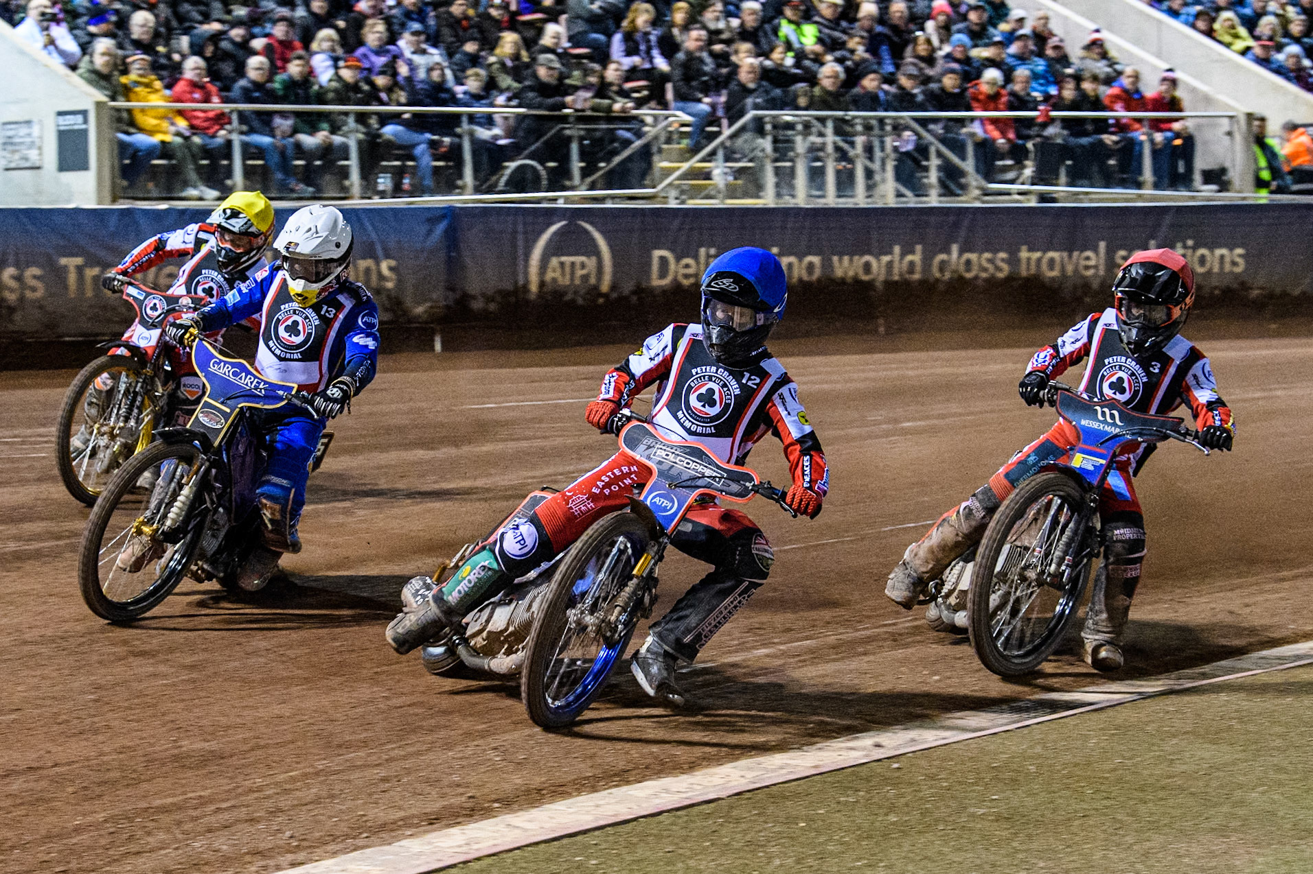 Australia's Brady Kurtz (Blue) inside England's Robert Lambert (White) with Australia's Ben Cook (Red) and England's Connor Mountain (Yellow) behind during the Peter Craven Memorial Trophy meeting at the National Speedway Stadium, Manchester on Monday 18th March 2024. (Photo: Ian Charles | MI News)