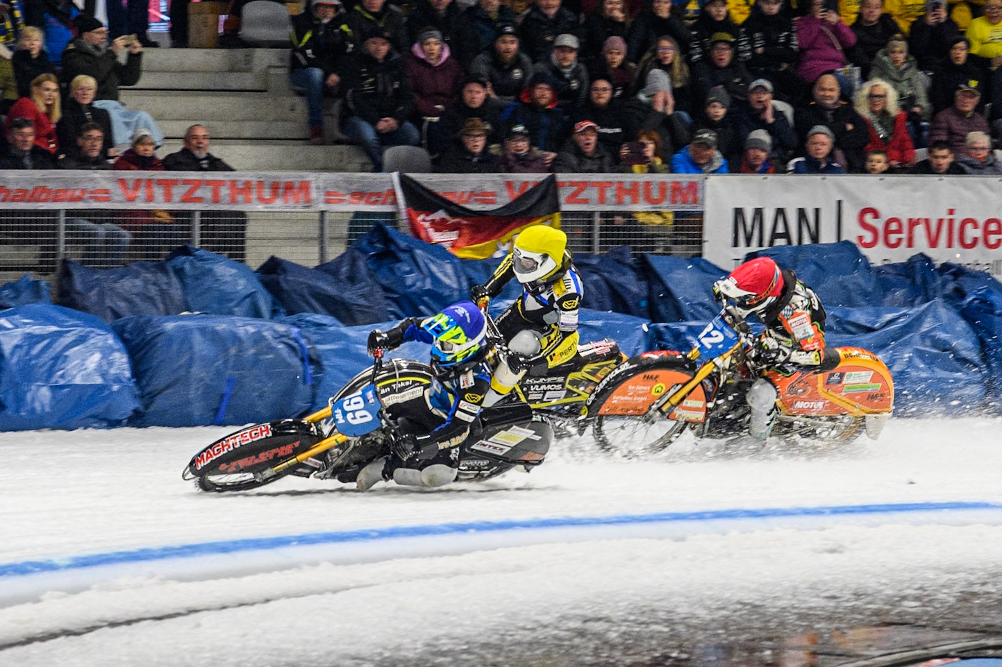 Sweden's Martin Haarahiltunen (199)  (Blue) leads  and Germany's Markus Jell (82) (Red) and Finland's Heikki Huusko (67)y\ collide and crash into the bales during the FIM Ice Speedway Gladiators World Championship Final 2 at the Max-Aicher-Arena, Inzell on Sunday 24 March 2024. (Photo: Ian Charles | MI News)