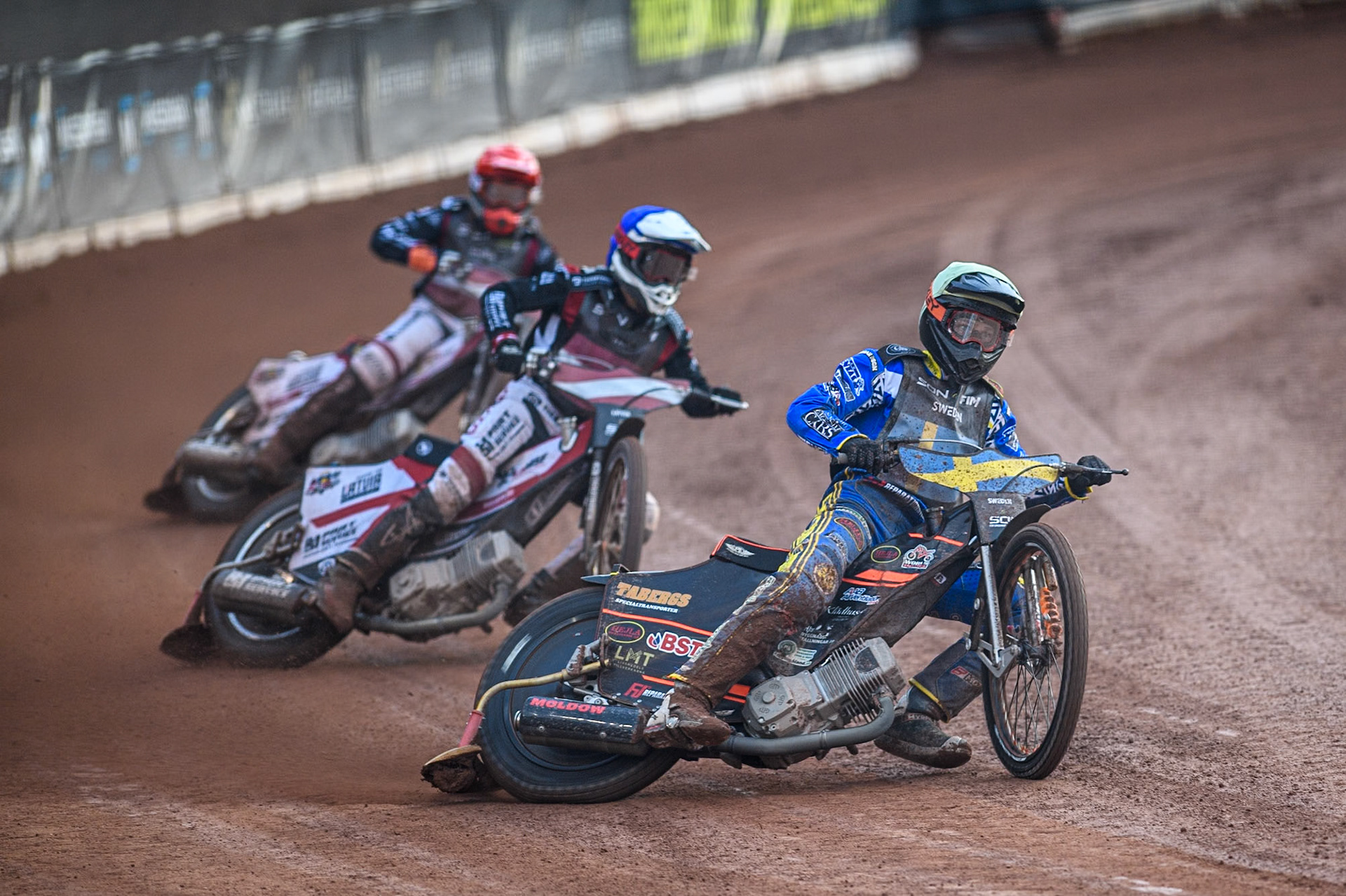 Fredrik Lindgren of Sweden in White leading Daniils Kolodinskis of Latvia in Blue and Andzejs Lebedevs of Latvia in Red  during the Monster Energy FIM Speedway of Nation Final at the National Speedway Stadium, Manchester on Saturday 13th July 2024. (Photo: Ian Charles | MI News)