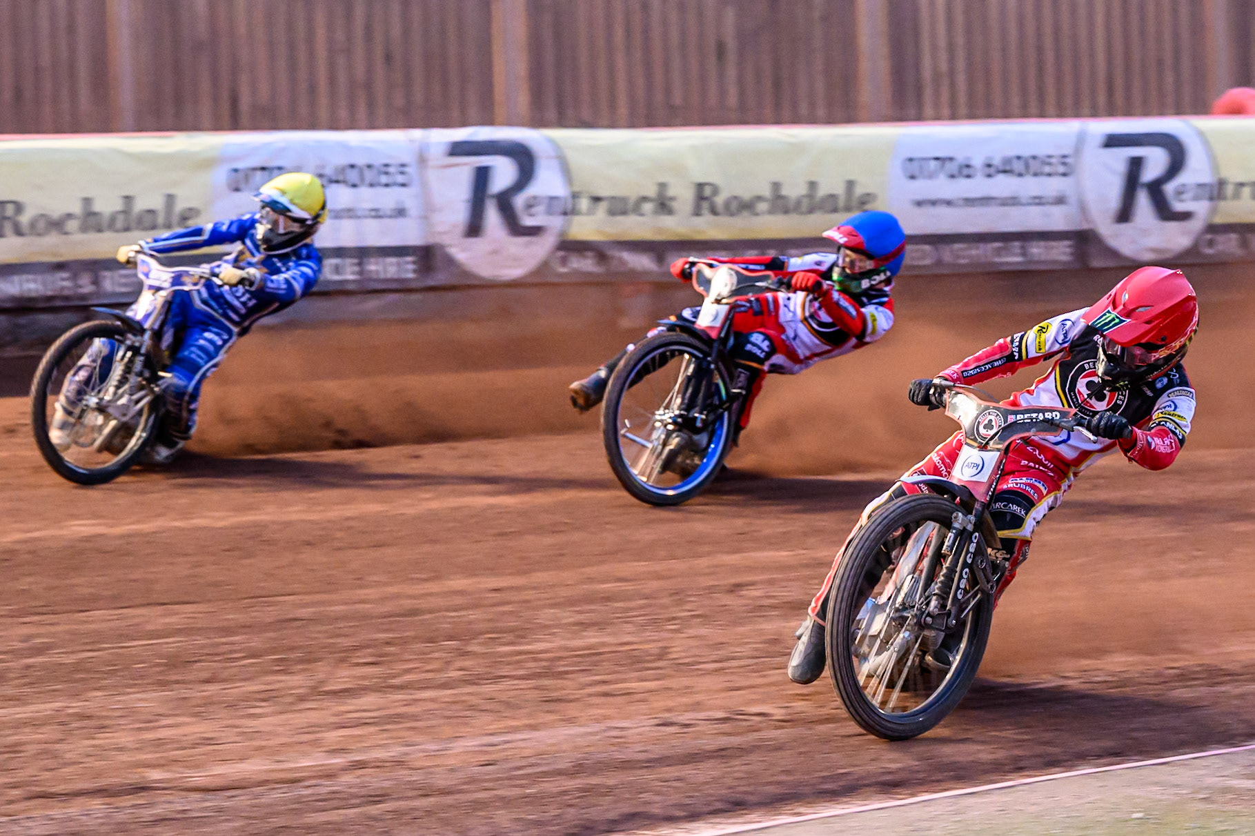Belle Vue Aces' Dan Bewley in Red rides inside Belle Vue Aces' Brady Kurtz in Blue and Kings Lynn Stars' Nicolai Klindt in Yellow during the Rowe Motor Oil Premiership match between Belle Vue Aces and King's Lynn Stars at the National Speedway Stadium, Manchester on Monday 23rd June 2025. (Photo: Ian Charles | MI News)
