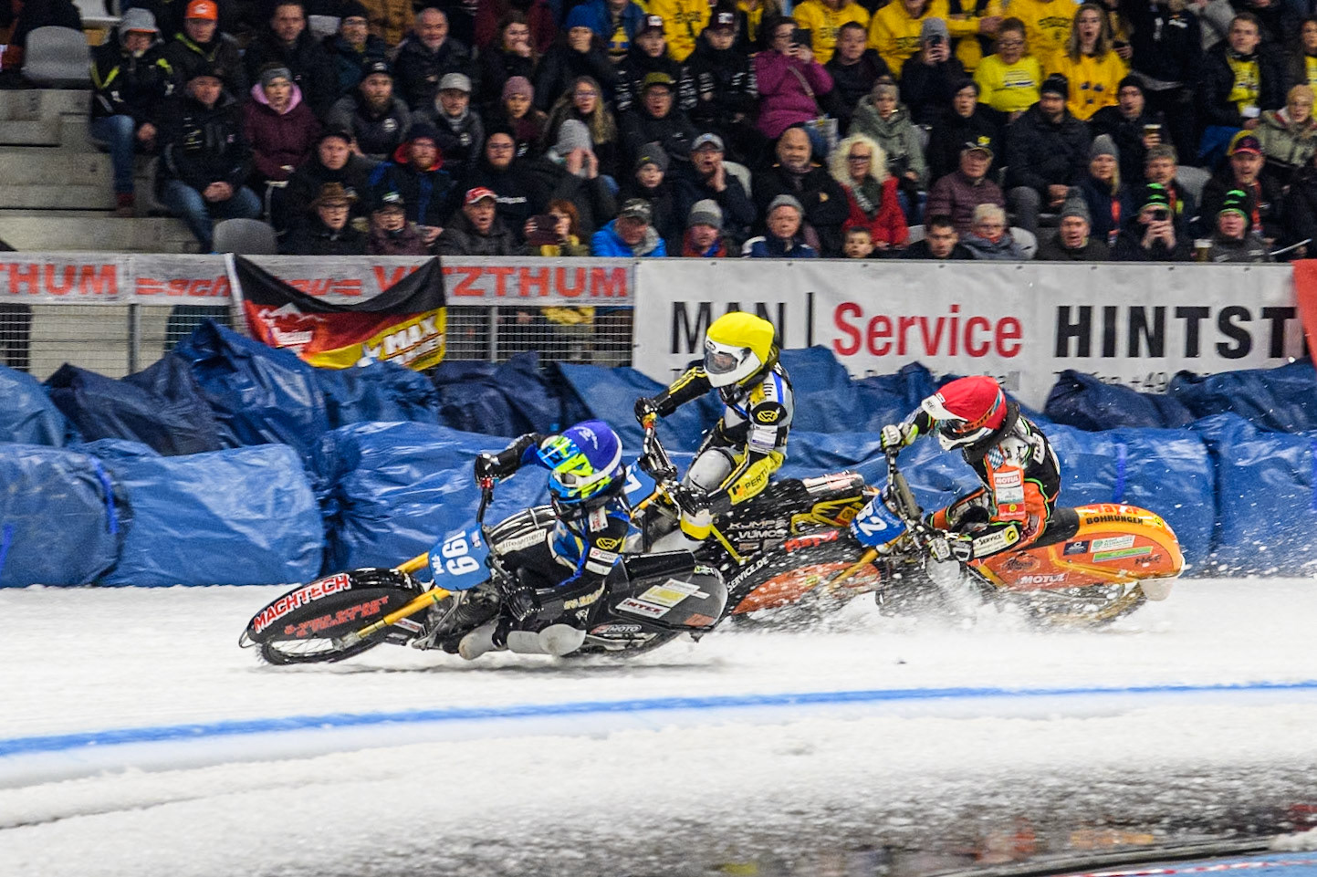 Sweden's Martin Haarahiltunen (199)  (Blue) leads  and Germany's Markus Jell (82) (Red) and Finland's Heikki Huusko (67)y\ collide and crash into the bales during the FIM Ice Speedway Gladiators World Championship Final 2 at the Max-Aicher-Arena, Inzell on Sunday 24 March 2024. (Photo: Ian Charles | MI News)