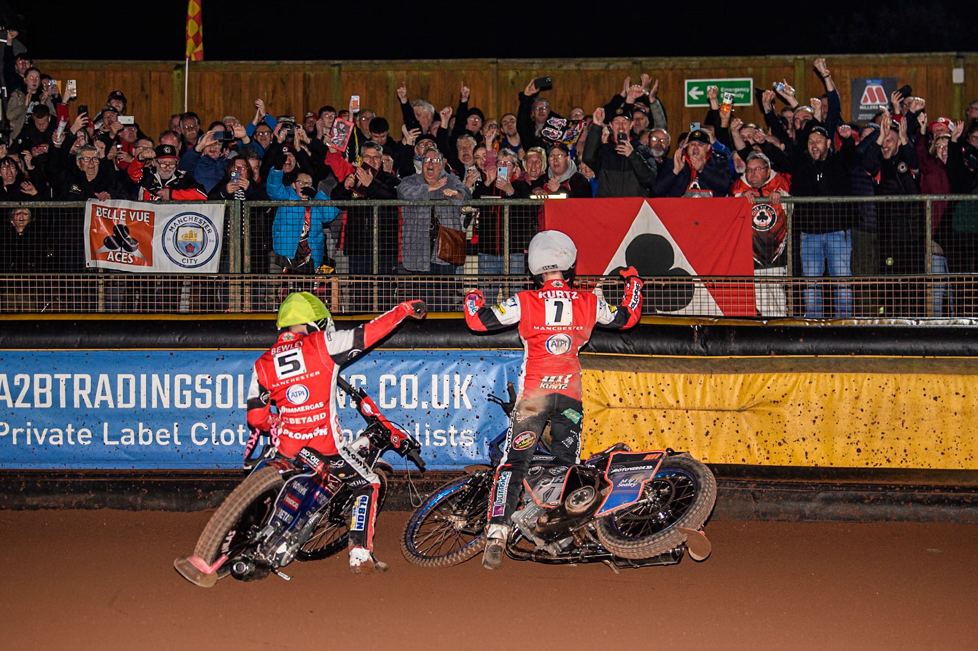 Belle Vue Aces' Dan Bewley (Left) and Belle Vue Aces' Brady Kurtz celebrate the title with the travelling Belle Vuee fans during the Rowe Motor Oil Premiership Grand Final 2nd Leg between Leicester Lions and Belle Vue Aces at the Pidcock Motorcycles Arena, Leicester on Thursday 26th September 2024. (Photo: Ian Charles | MI News)