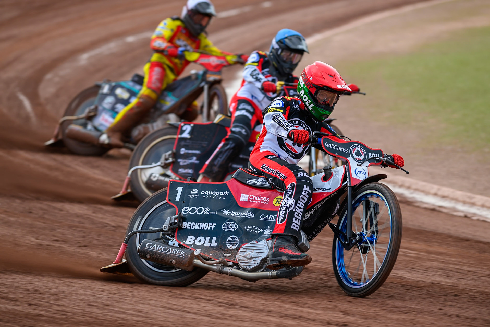 Brady Kurtz of Belle Vue Aces in Red leading Norick Blödorn of Belle Vue Aces in Blue and Ryan Douglas of Leicester Lions in White during the Rowe Motor Oil Premiership match between Belle Vue Aces and Leicester Lions at the National Speedway Stadium, Manchester on Monday 3rd August 2026. (Photo: Ian Charles | MI News)