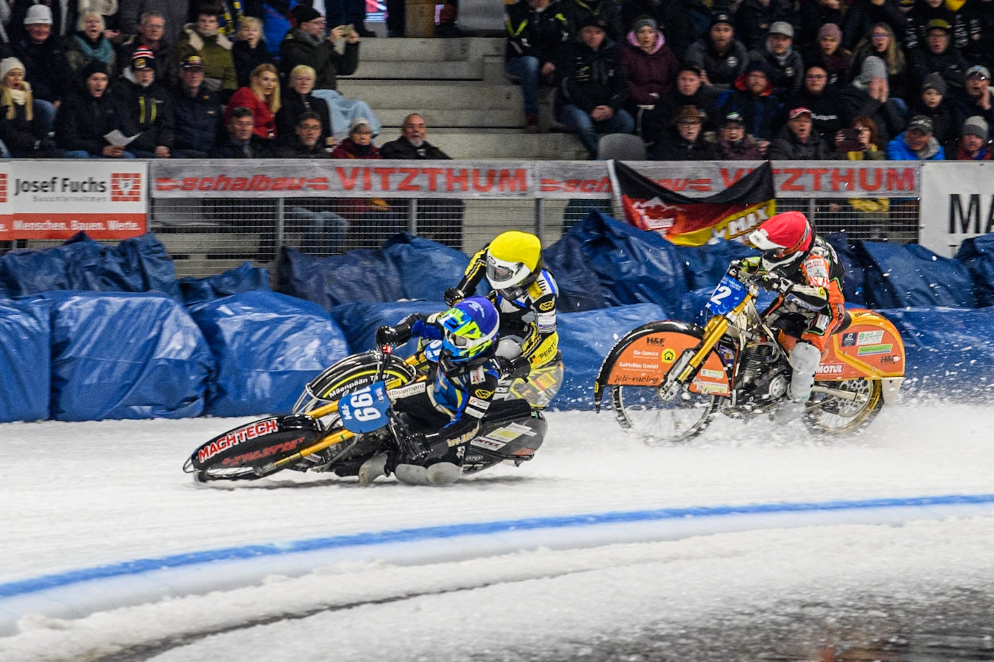 Sweden's Martin Haarahiltunen (199)  (Blue) leads  and Germany's Markus Jell (82) (Red) and Finland's Heikki Huusko (67)y\ collide and crash into the bales during the FIM Ice Speedway Gladiators World Championship Final 2 at the Max-Aicher-Arena, Inzell on Sunday 24 March 2024. (Photo: Ian Charles | MI News)