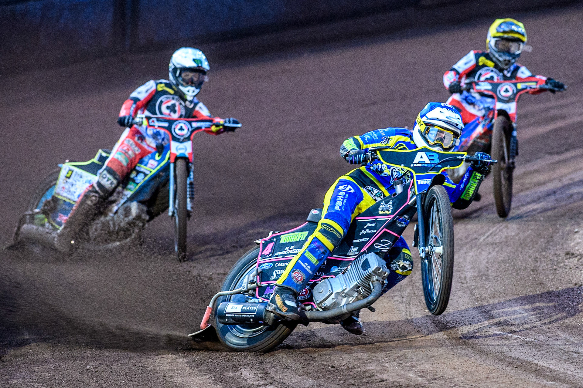 Sheffield Tigers' Josh Pickering  in Blue picks up some drive whilst leading Belle Vue Aces' Jaimon Lidsey  in White and Belle Vue Aces' Ben Cook  in Yellow during the Rowe Motor Oil Premiership match between Sheffield Tigers and Belle Vue Aces at Owlerton Stadium, Sheffield on Monday 26th August 2024. (Photo: Ian Charles | MI News)