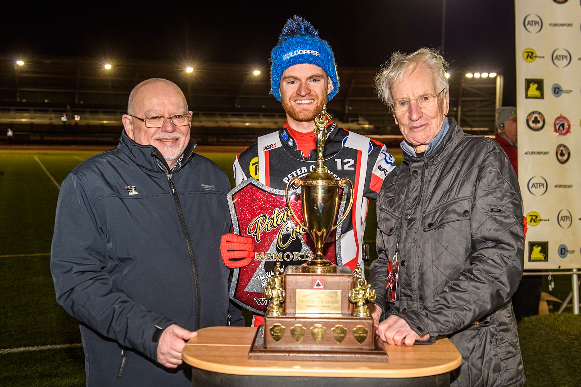 (L to R) Robert Craven, son of  Peter Craven, Brady Kurtz, and Ove Fundin with the trophy after Kurtz win during the Peter Craven Memorial Trophy meeting at the National Speedway Stadium, Manchester on Monday 18th March 2024. (Photo: Ian Charles | MI News)