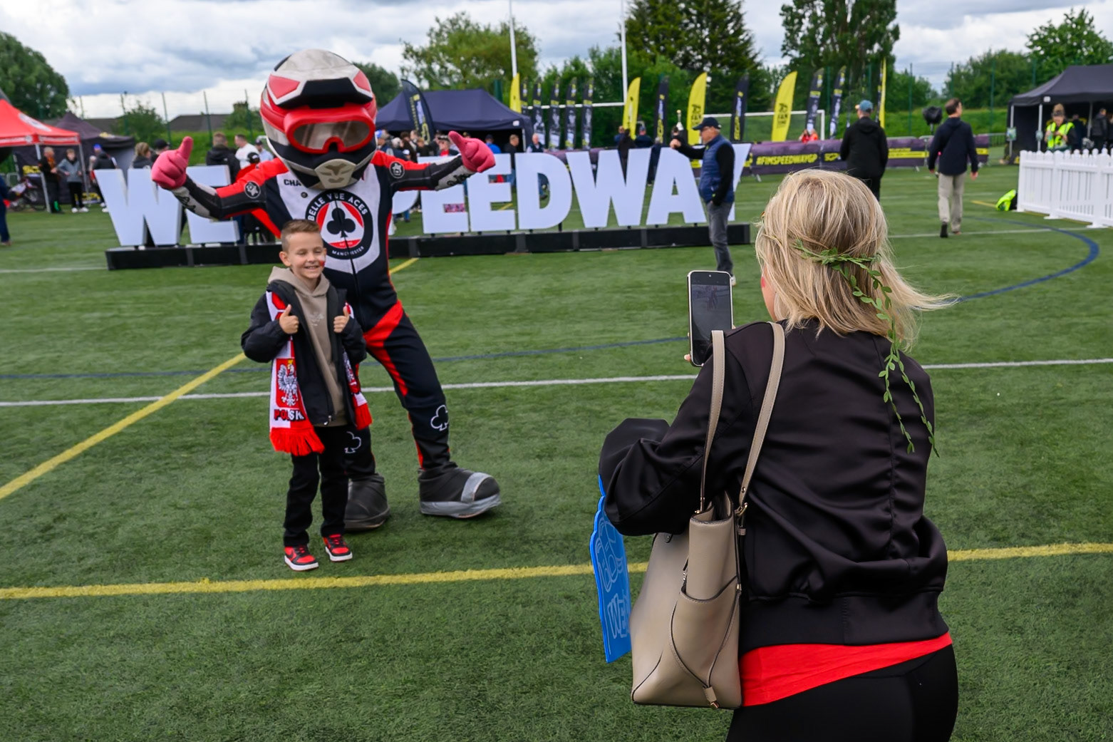 Fan takes a picture of her son with Belle Vue Aces mascot Chase The Ace during the ATPI  FIM Speedway GP of Manchester at the National Speedway Stadium, Manchester on Saturday 6th June 2026. (Photo: Ian Charles | MI News)