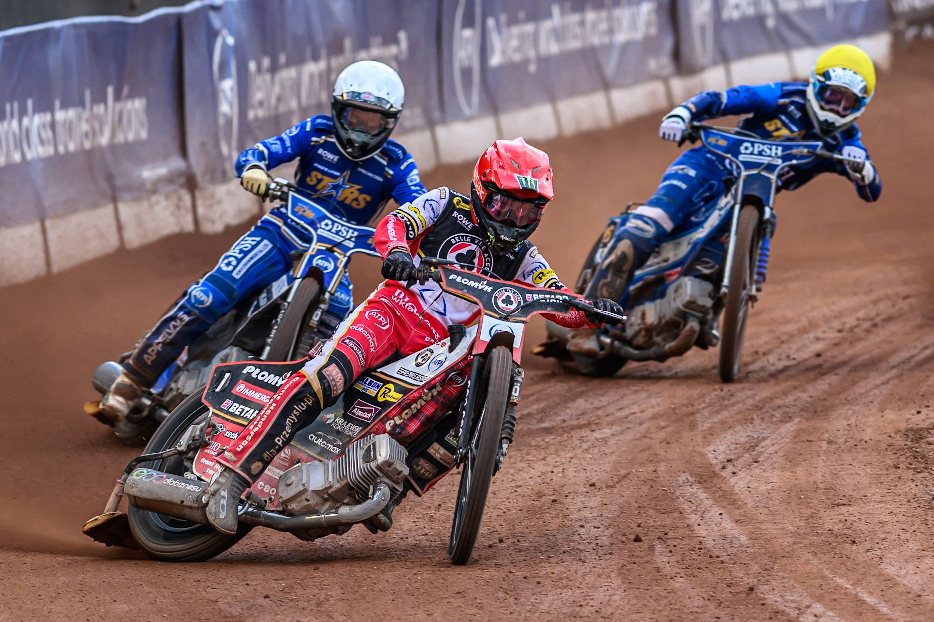 Belle Vue Aces' Dan Bewley in Red leading Kings Lynn Stars' Nicolai Klindt in White and Kings Lynn Stars' Guest Rider, Anders Rowe in Yellow during the Rowe Motor Oil Premiership match between Belle Vue Aces and King's Lynn Stars at the National Speedway Stadium, Manchester on Monday 23rd June 2025. (Photo: Ian Charles | MI News)