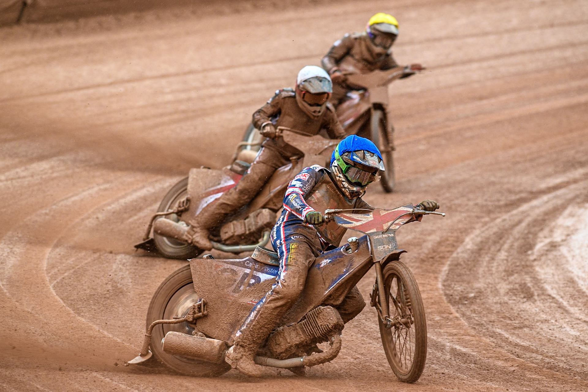 Leon Flint of Great Britain in Blue leading Nikita Kaulins of Latvia in White and Artjoms Juhno of Latvia in Yellow during the Monster Energy FIM Speedway of Nations 2 (Under 21) Final at the National Speedway Stadium, Manchester on Friday 12th July 2024. (Photo: Ian Charles | MI News)