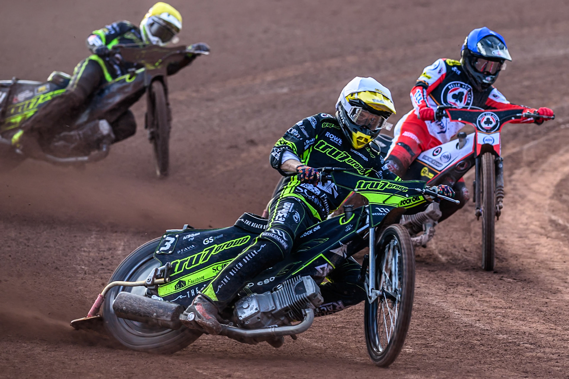 Ipswich Witches' Adam Ellis  in White leading Belle Vue Aces' Zach Cook  in Blue and Ipswich Witches' Tom Brennan  in Yellow during the Rowe Motor Oil Premiership match between Belle Vue Aces and Ipswich Witches at the National Speedway Stadium, Manchester on Monday 30th June 2025. (Photo: Ian Charles | MI News)