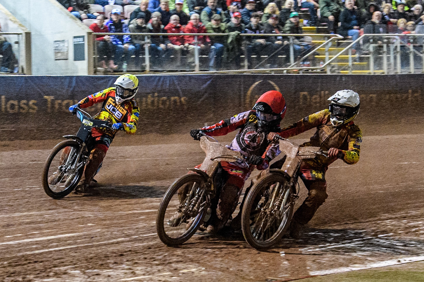 Leicester Lions' Max Fricke  in White and Belle Vue Aces' Brady Kurtz  in Red get a bit close with Leicester Lions' Ryan Douglas  in Yellow behind during the Rowe Motor Oil Premiership Grand Final 1st Leg between Belle Vue Aces and Leicester Lions at the National Speedway Stadium, Manchester on Monday 23rd September 2024. (Photo: Ian Charles | MI News)
