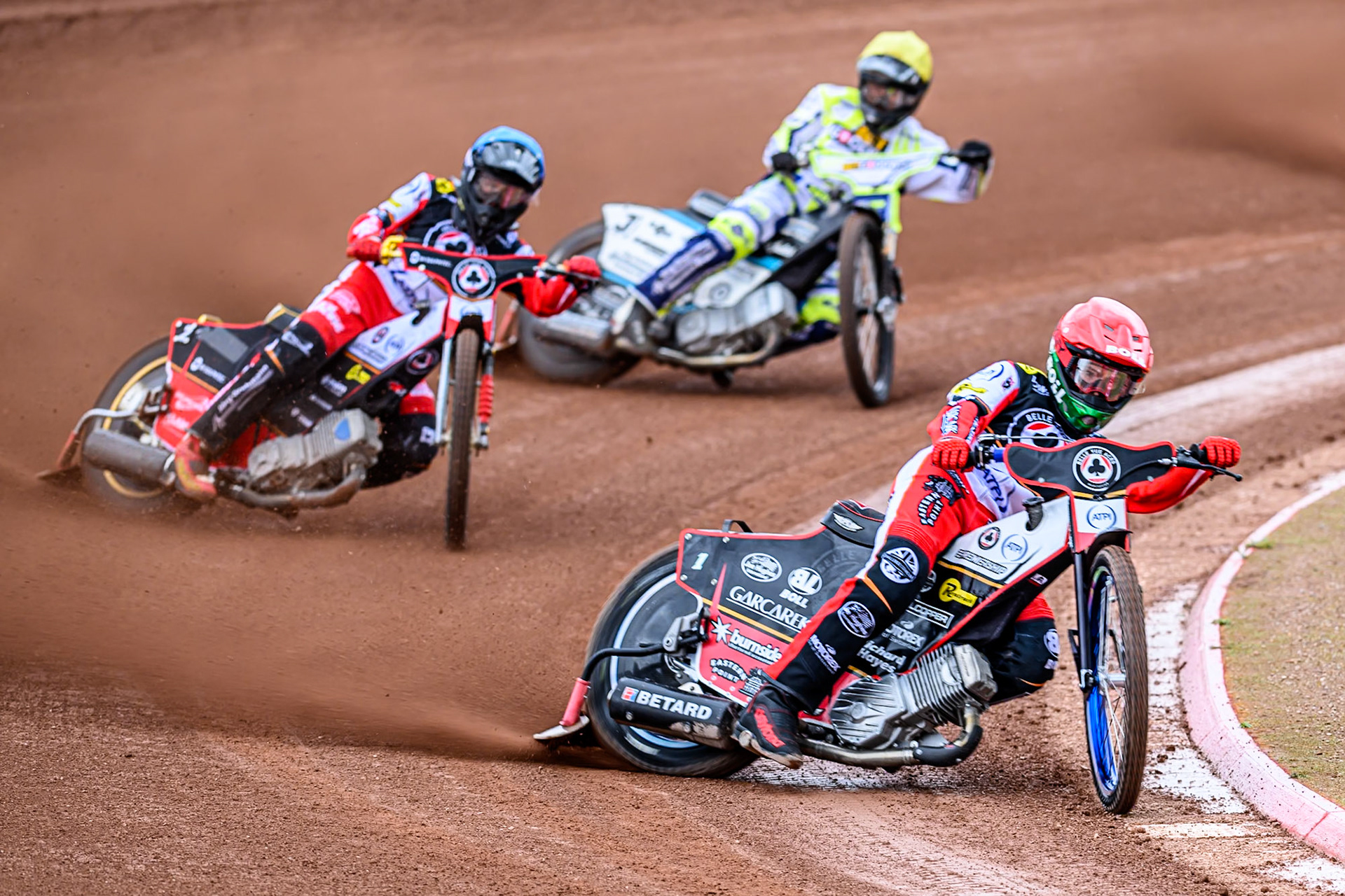 Belle Vue Aces' Brady Kurtz in Red leading Belle Vue Aces' Norick Blödorn in Blue and Oxford Spires' Erik Riss in Yellow during the Rowe Motor Oil Premiership match between Belle Vue Aces and Oxford Spires at the National Speedway Stadium, Manchester on Monday 26th May 2025. (Photo: Ian Charles | MI News)