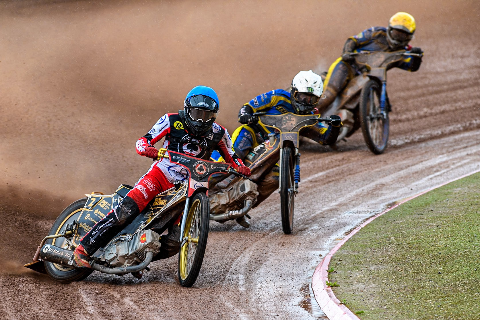 Belle Vue Aces' Norick Blodorn in Blue leading Sheffield Tigers' Jack Holder in White and Sheffield Tigers' Kyle Howarth in Yellow during the Rowe Motor Oil Premiership match between Belle Vue Aces and Sheffield Tigers at the National Speedway Stadium, Manchester on Monday 27th May 2024. (Photo: Ian Charles | MI News)
