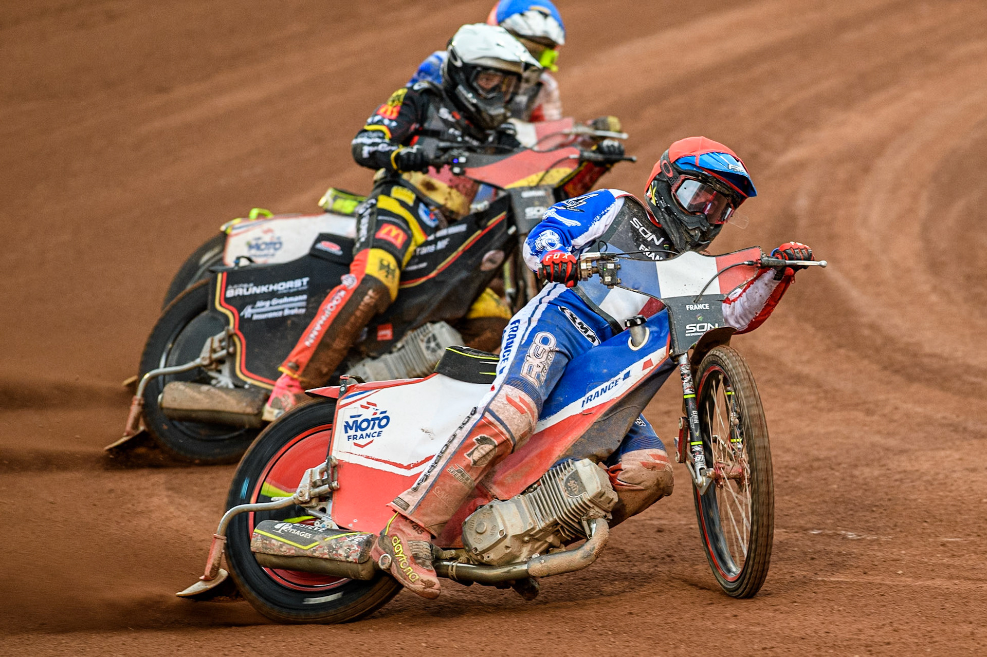France v Germany: Jesse Mustonen of Finland in Red leading Kai Huckenbeck of Germany in White and Steven Goret of France in Blue during the Monster Energy FIM Speedway of Nations Semi-Final 1 at the National Speedway Stadium, Manchester on Tuesday 9th July 2024. (Photo: Ian Charles | MI News)