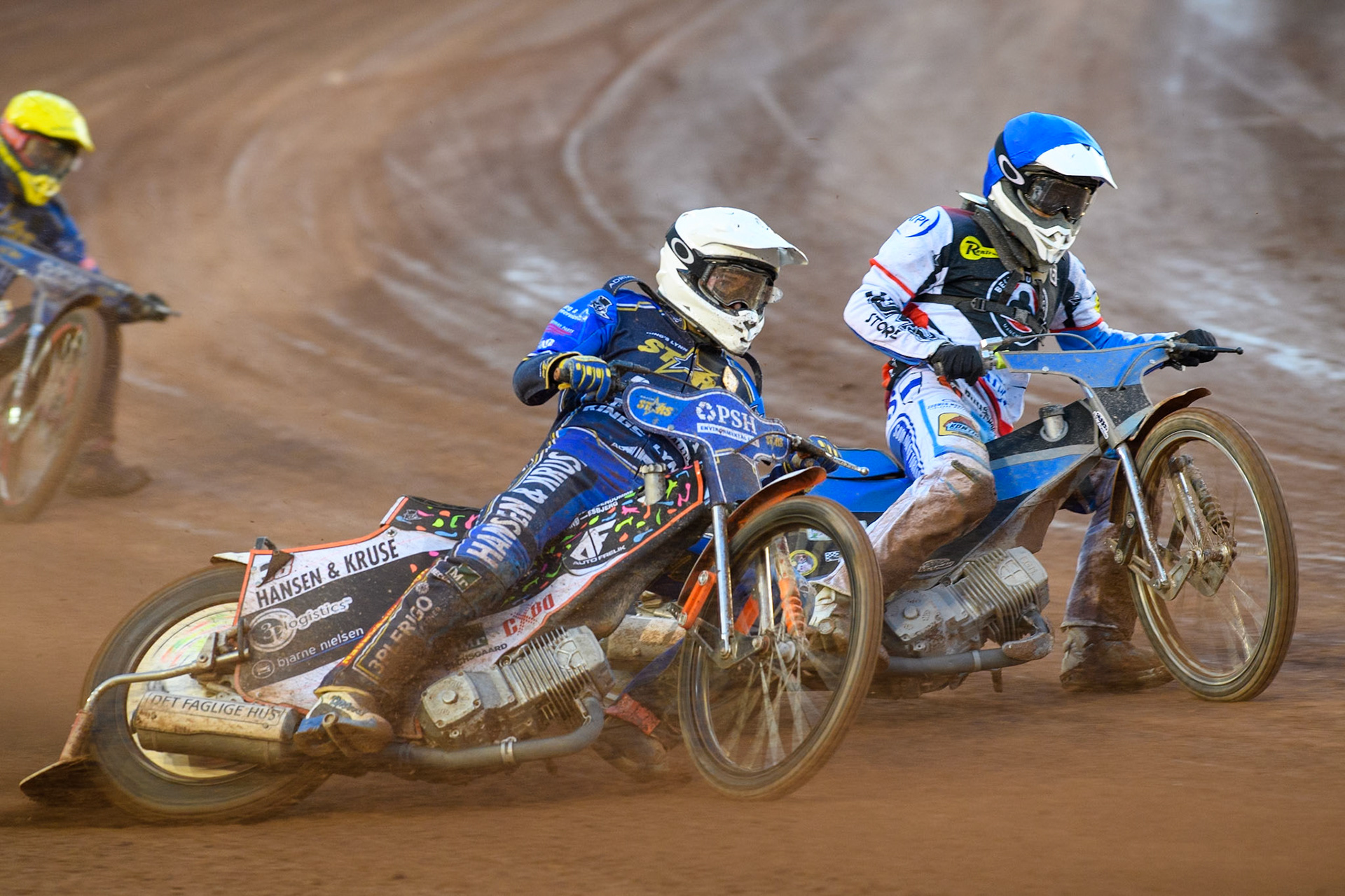 Kings Lynn Stars' Niels-Kristian Iversen in White rides outside Belle Vue Aces' Antti Vuolas  in Blue during the Rowe Motor Oil Premiership match between Belle Vue Aces and King's Lynn Stars at the National Speedway Stadium, Manchester on Monday 12th August 2024. (Photo: Ian Charles | MI News)