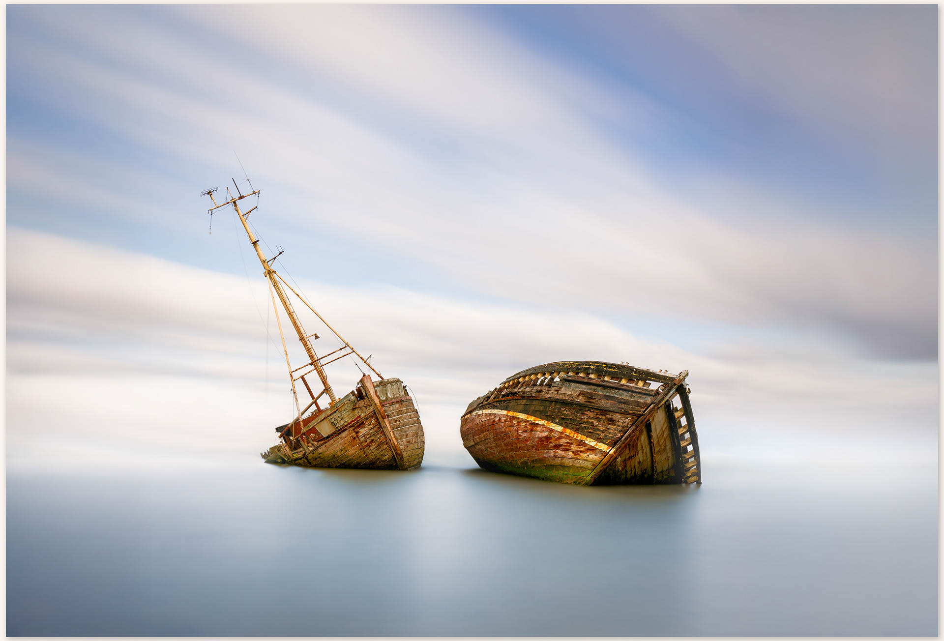 a long exposure photo of the two main wrecks at pin mill.  the sky and water are blurred to place greater emphasis on the wrecks.