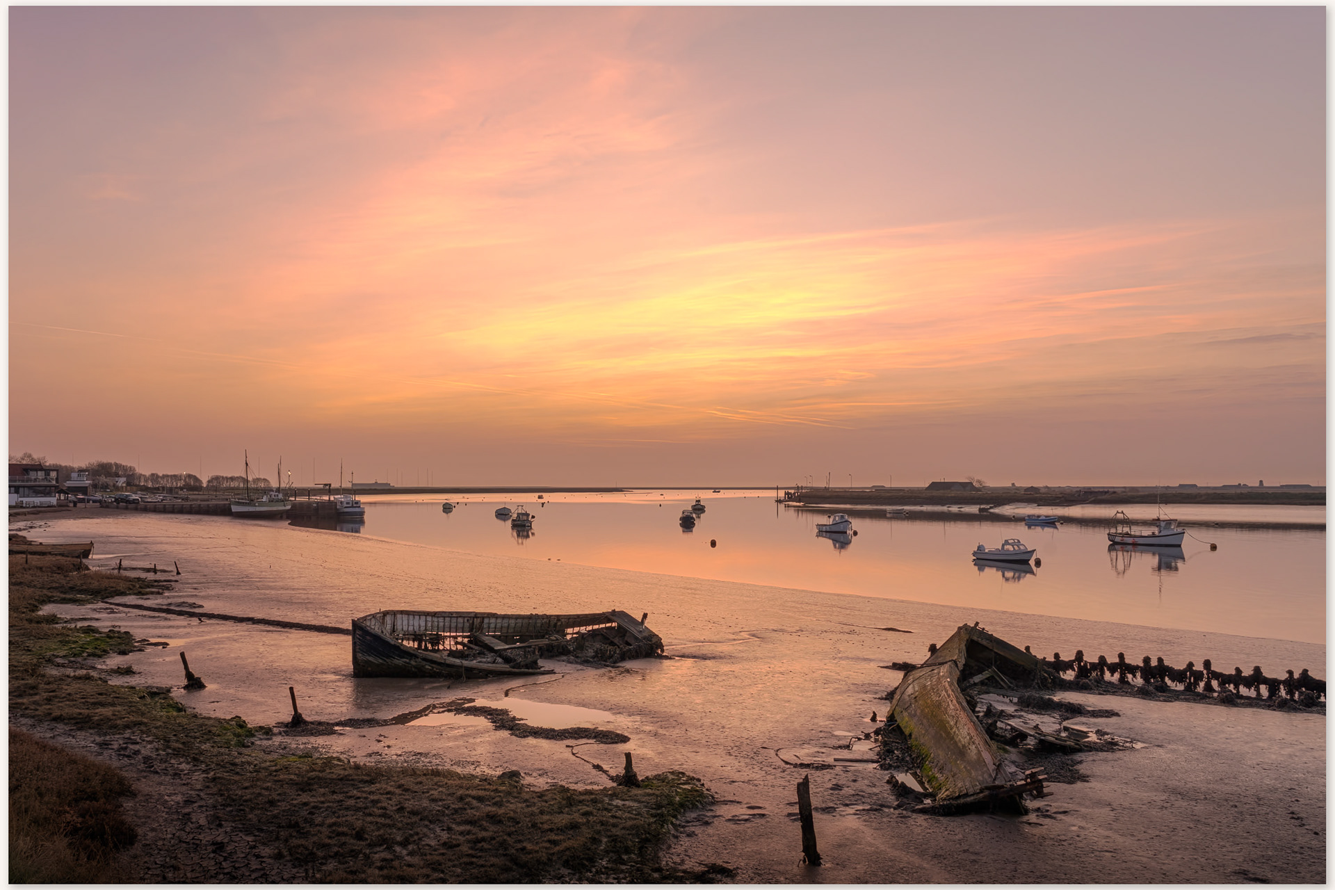 sunrise over Orford ness with the wrecks of two old boats stranded in the mud in the foreground