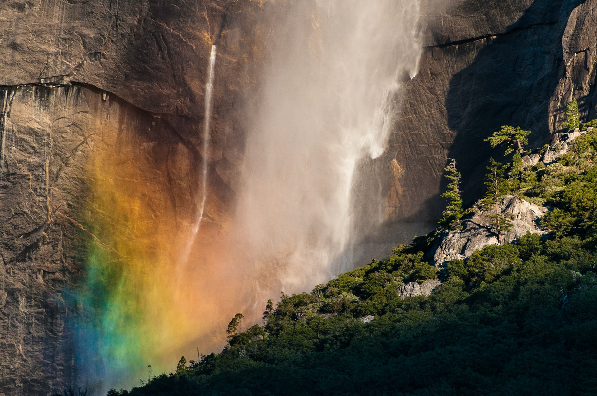 The mist from Upper Yosemite Falls creates a rainbow when lit by the early morning light.