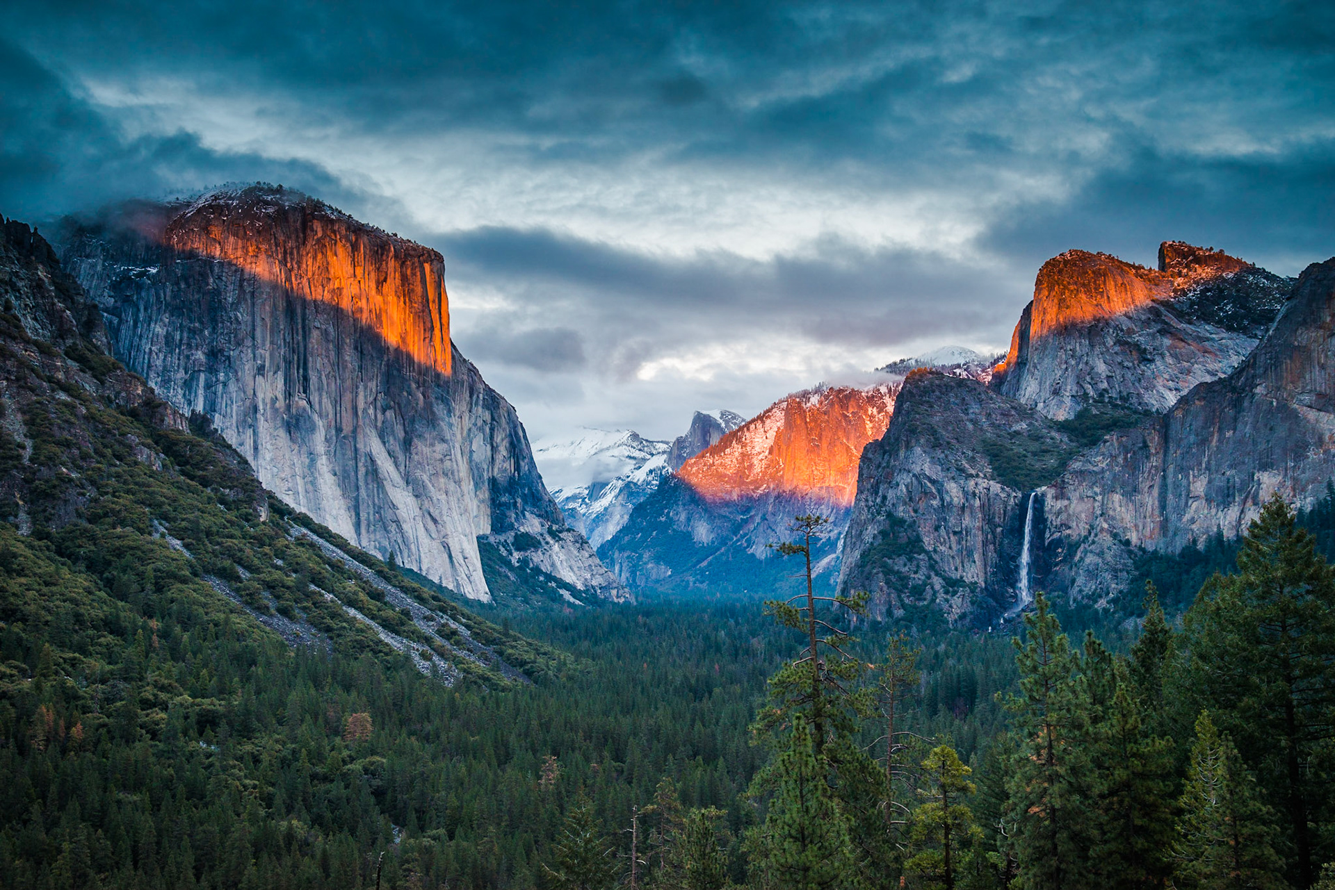 Evening light breaks through the clouds as a storm clears over Yosemite Valley.