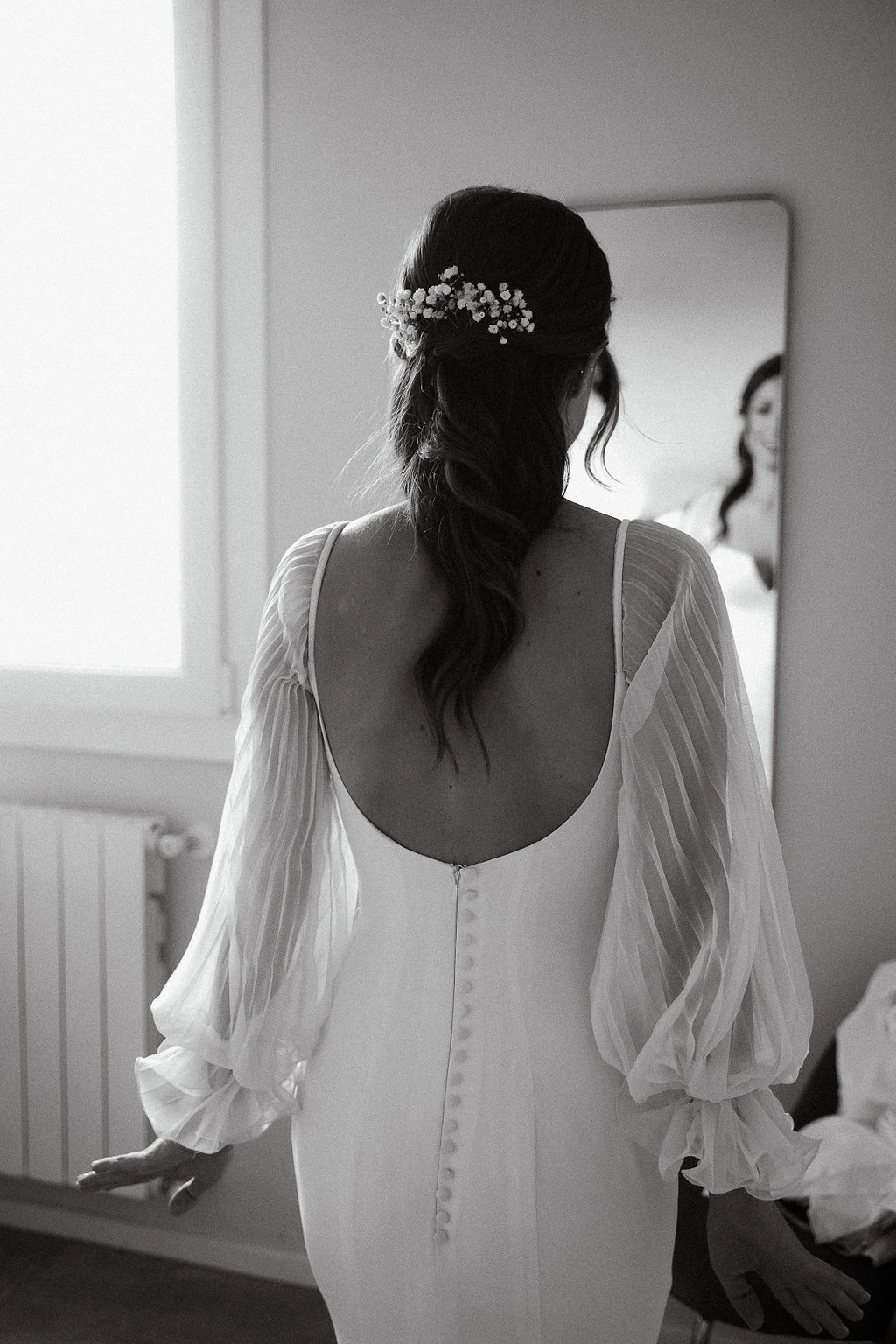 Fotografia di Arianna Macherelli, specializzata in Fotografia di Matrimonio, dettaglio in bianco e nero della sposa che si guarda allo specchio di spalle