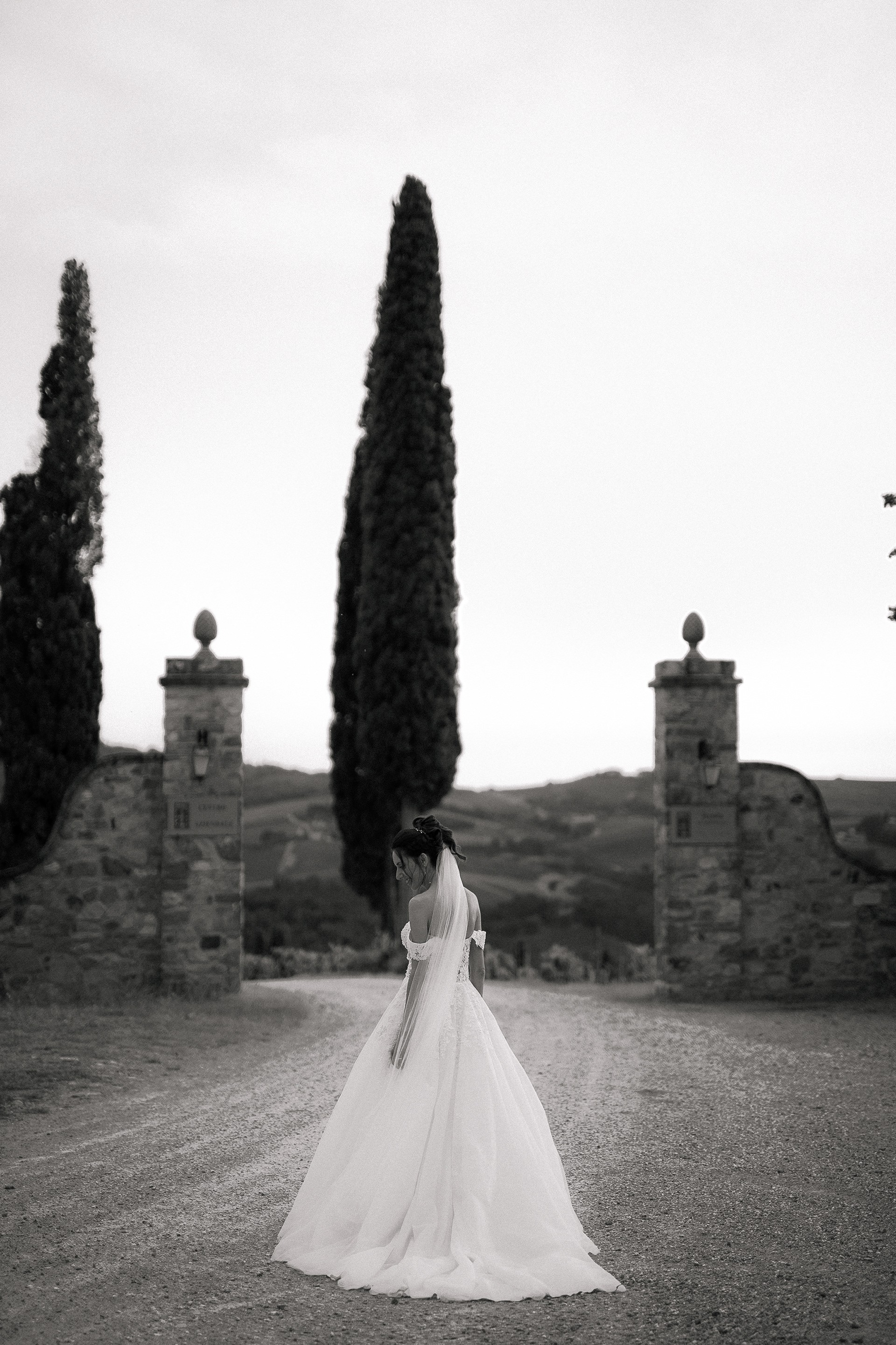 Fotografia di Arianna Macherelli, specializzata in Fotografia di Matrimonio, Sposa che si volta immersa nel paesaggio toscano
