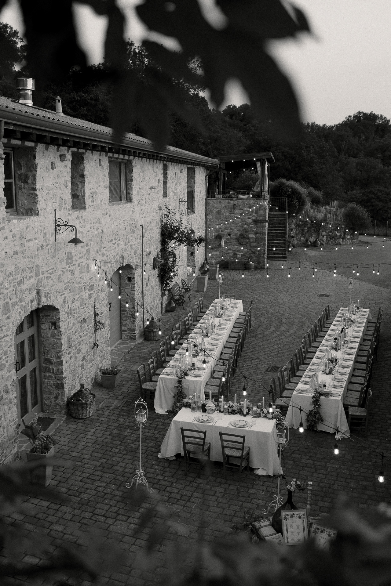 Fotografia di Arianna Macherelli, specializzata in Fotografia di Matrimonio immagine in bianco e nero vista dall'alto con tavoli apparecchiati