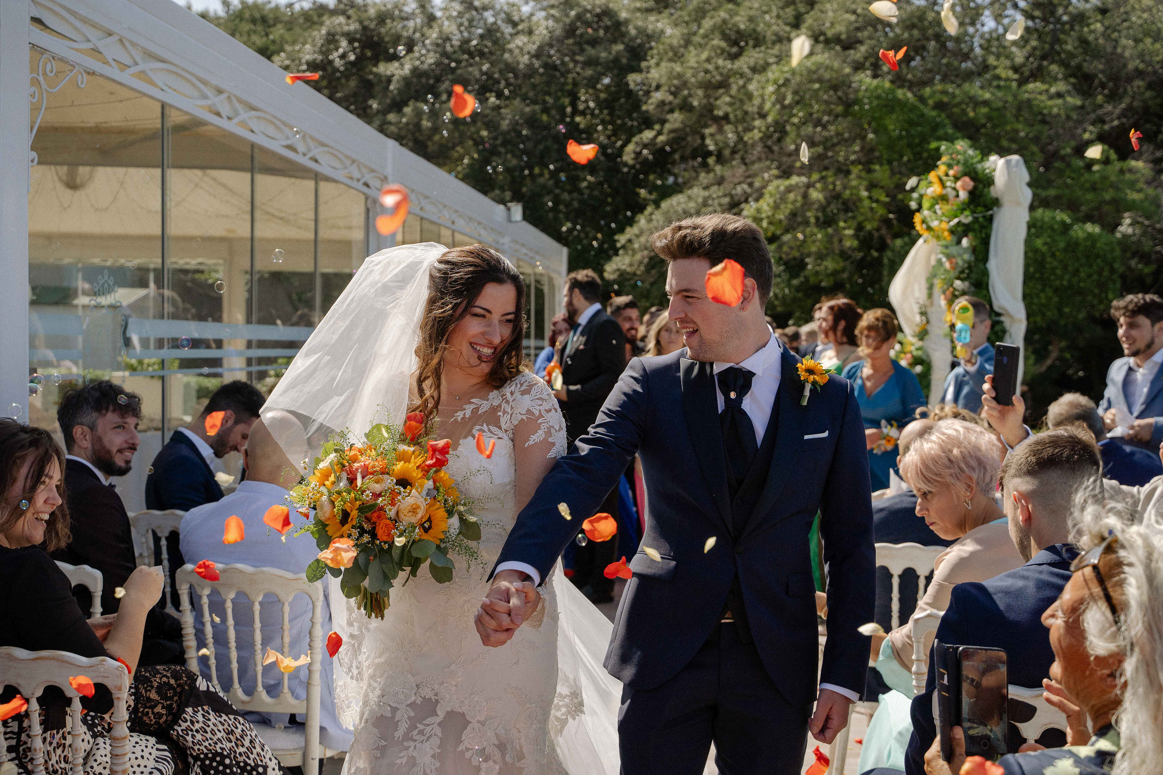 Fotografia di Arianna Macherelli, specializzata in Fotografia di Matrimonio, immagine reportage dell'uscita degli sposi con il lancio dei petali