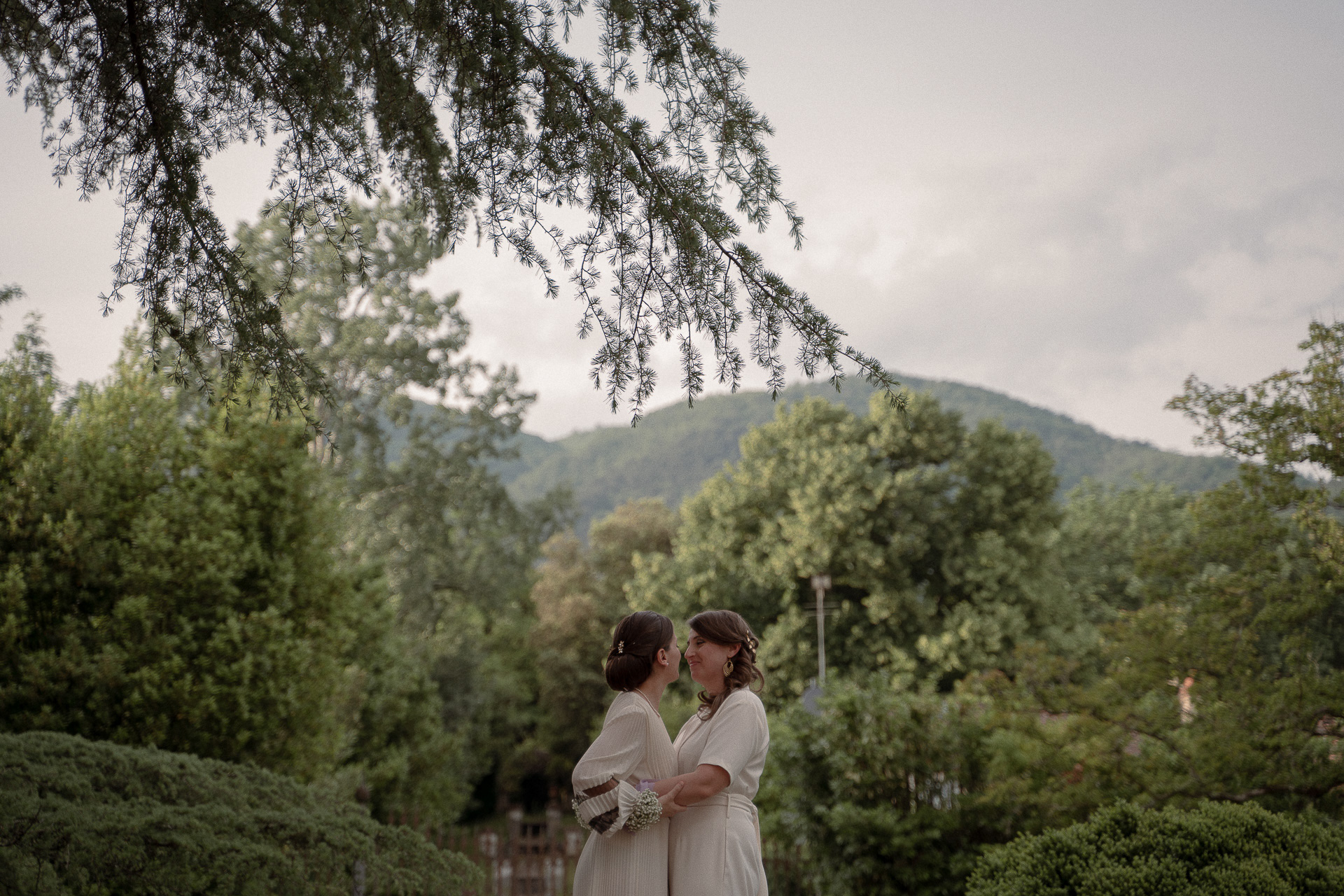 Fotografia di Arianna Macherelli, specializzata in Fotografia di Matrimonio, ritratto di due spose che si baciano immerse nella natura