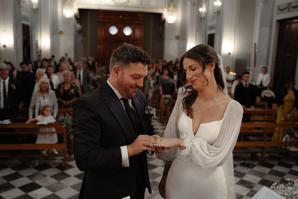 Fotografia di Arianna Macherelli, specializzata in Fotografia di Matrimonio, ritratto degli sposi mentre si scambiano le fedi nuziali in chiesa